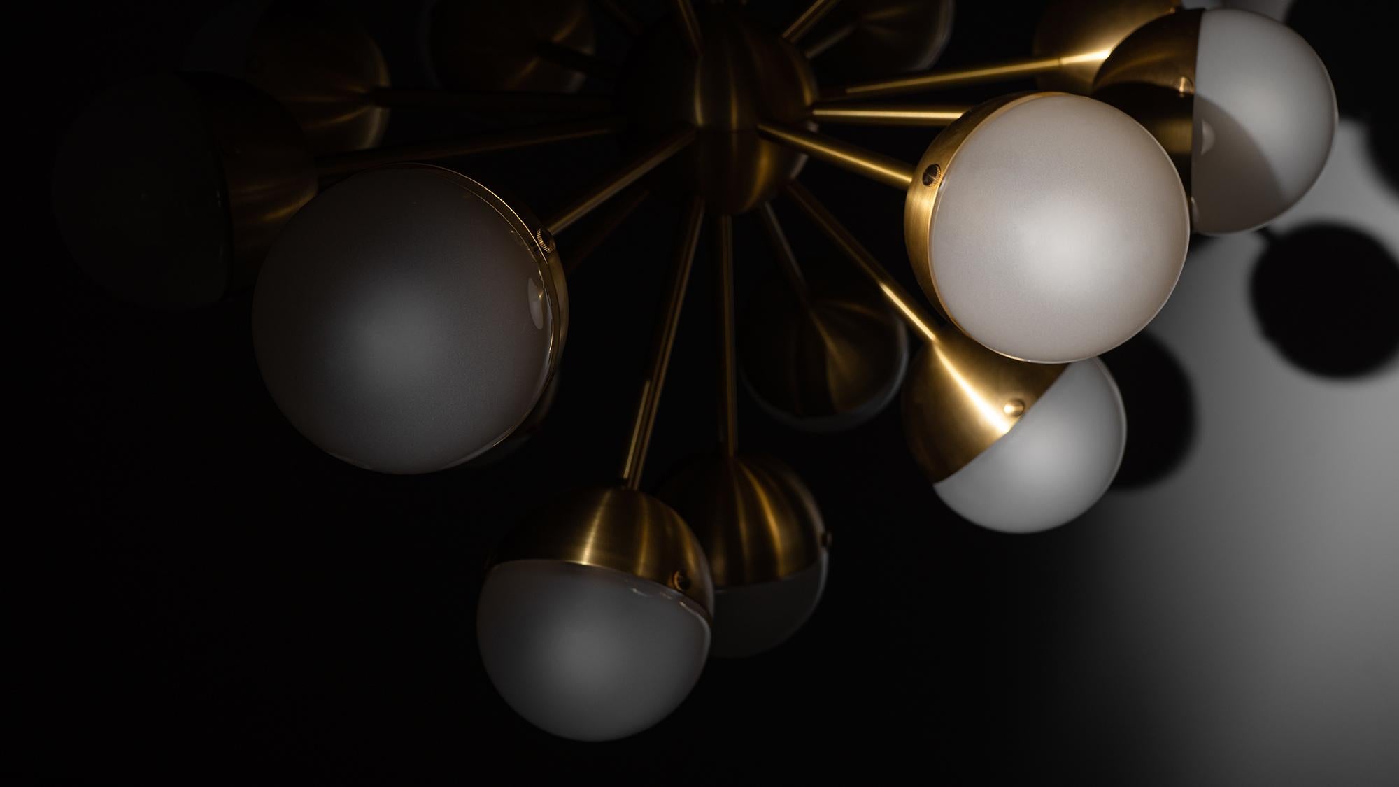 Sparks of light trail brass lines in a circular formation. Radiating out from a spherical nucleus, seventeen sprightly rods wield illuminated hemispheres, spectacular spatial punctuation.

Available in our three signature finishes: Lacquered