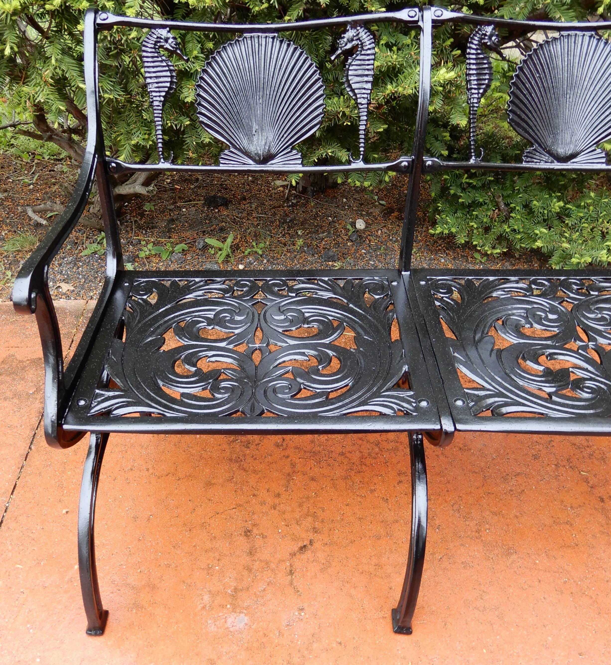 A cast aluminium garden bench by Molla in the shell and seahorse pattern. Molla is famous for making the shell and seahorse pattern for the garden. This desireable pattern furnished the patio gardens of the famous Breakers Hotel in Palm Beach. It