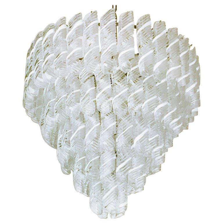 Lampadario italiano con vetri di Murano a righe bianche e trasparenti soffiati a mano per produrre eleganti volute, montati su una montatura con finitura cromata / Made in Italy
10 luci / 9 di tipo E26 o E27, max 60W ciascuna e 1 di tipo E12 o E14,