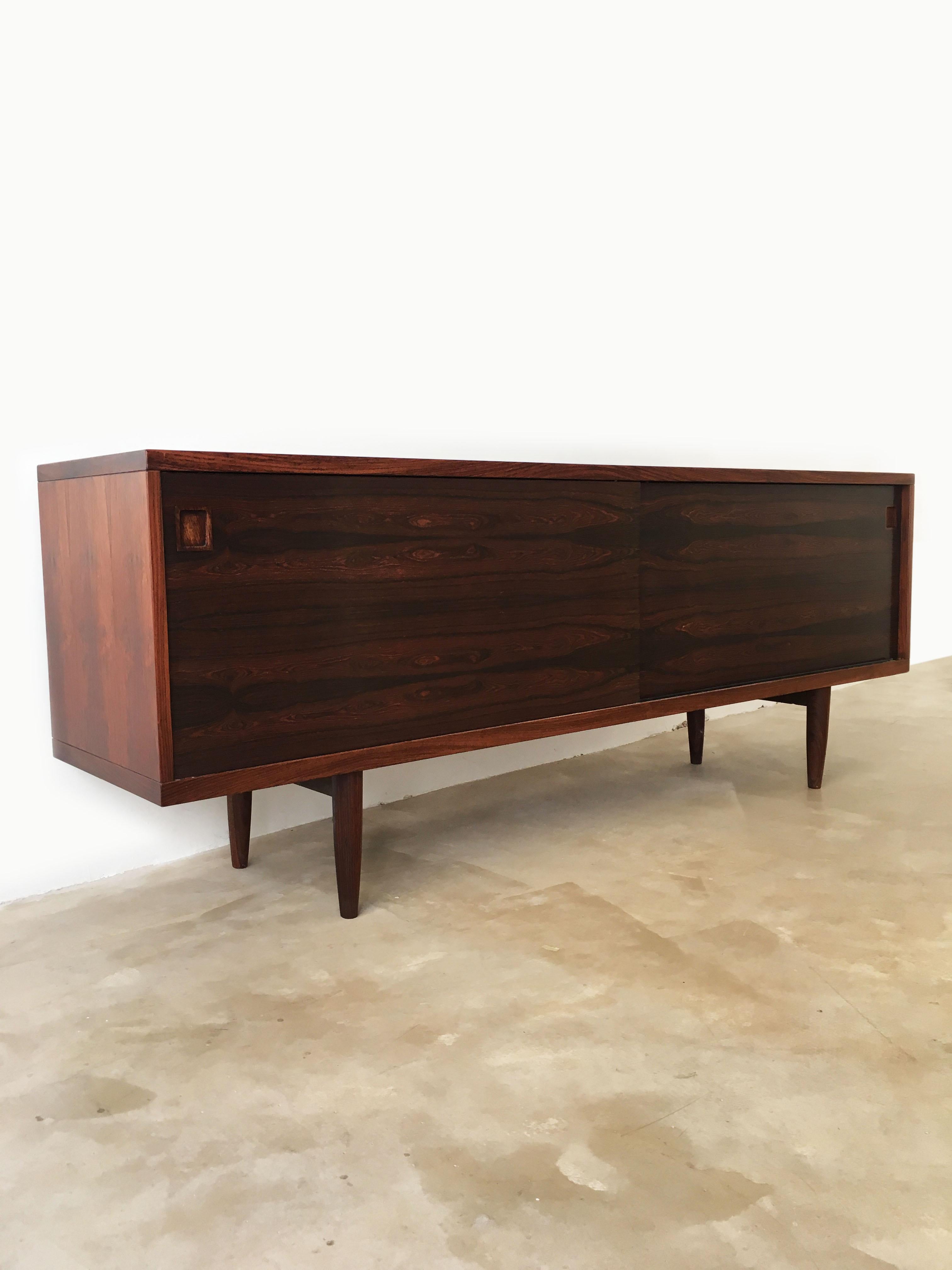 Rare Moller sideboard No 20 with book matched veneer, a noticed smooth design where the beautiful wood grain falls into focus on the two sliding doors. The top is carved in a soft curve around the edge, giving this piece an extra dimension that at