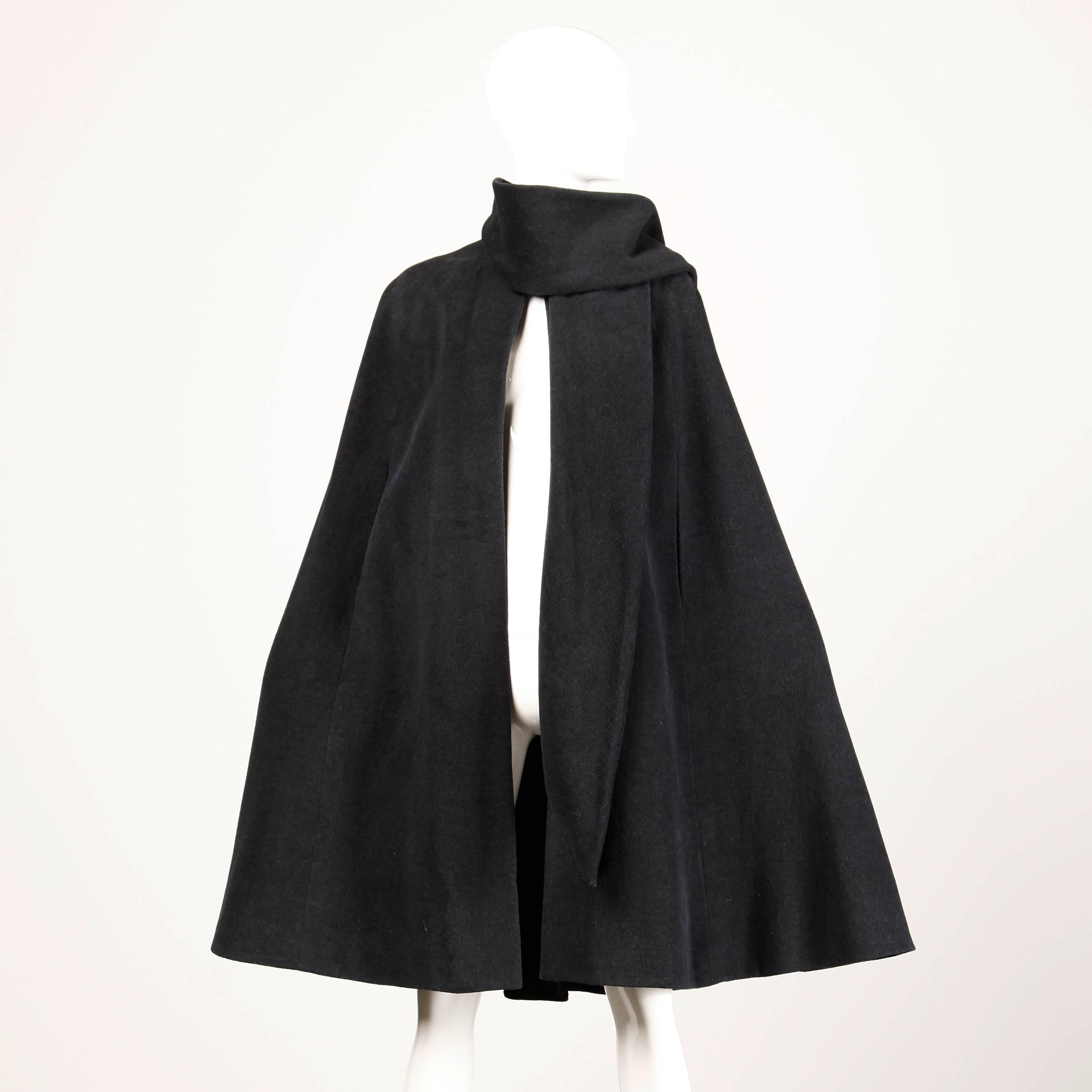 Chic 1960s charcoal gray wool cape coat with attached scarf by Mollie Parnis. Front arm slits and single hook closure at the neck.

Details: 

Fully Lined
Top Hook Closure
Marked Size: 6
Estimated Size: Free (XS-XL)
Color: Charcoal Gray
Fabric: