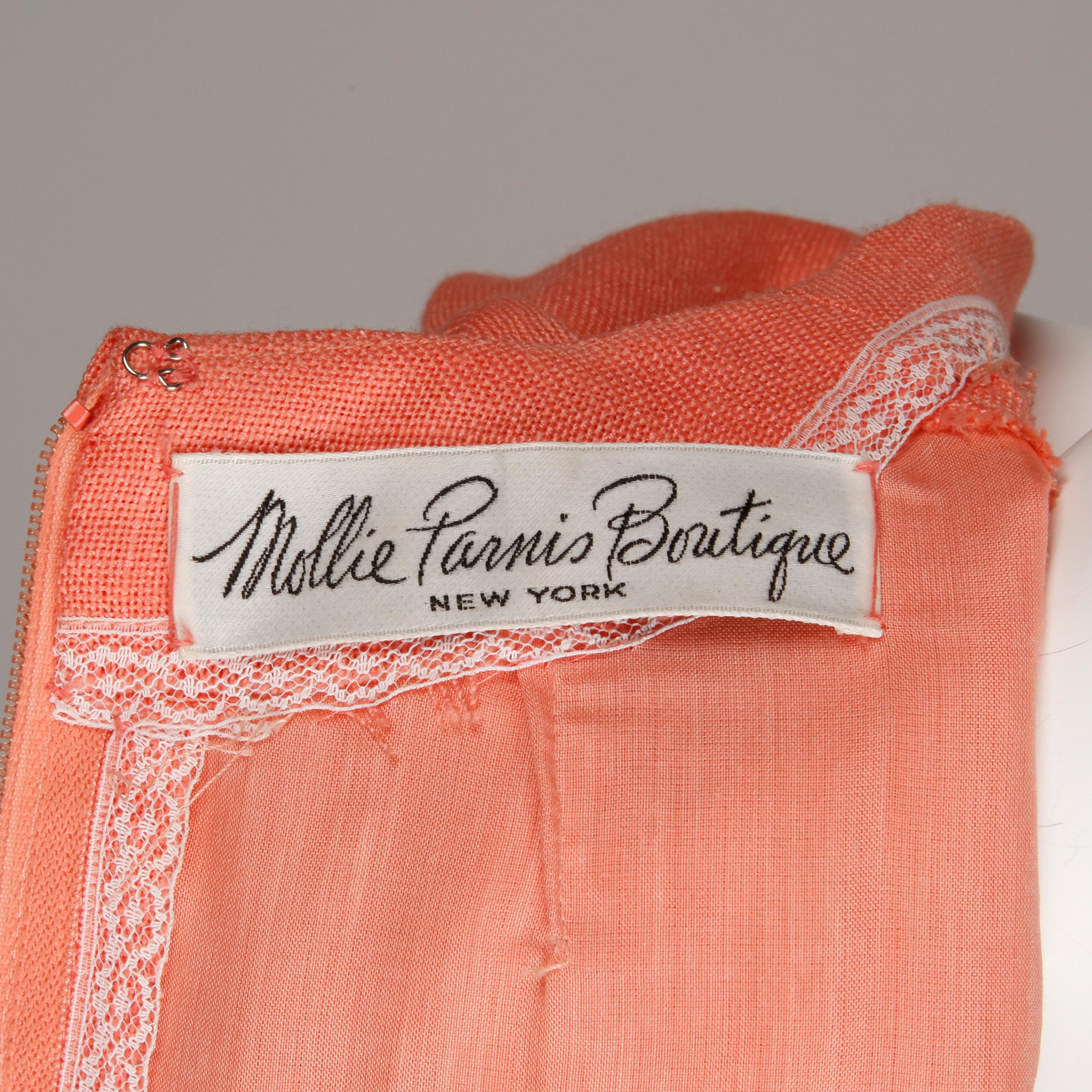 Beautifully done vintage 1960s coral linen dress by Mollie Parnis with short sleeves and a front box pleat. Fully lined with rear zip and hook closure. Fits like a modern size medium. The bust measures 38
