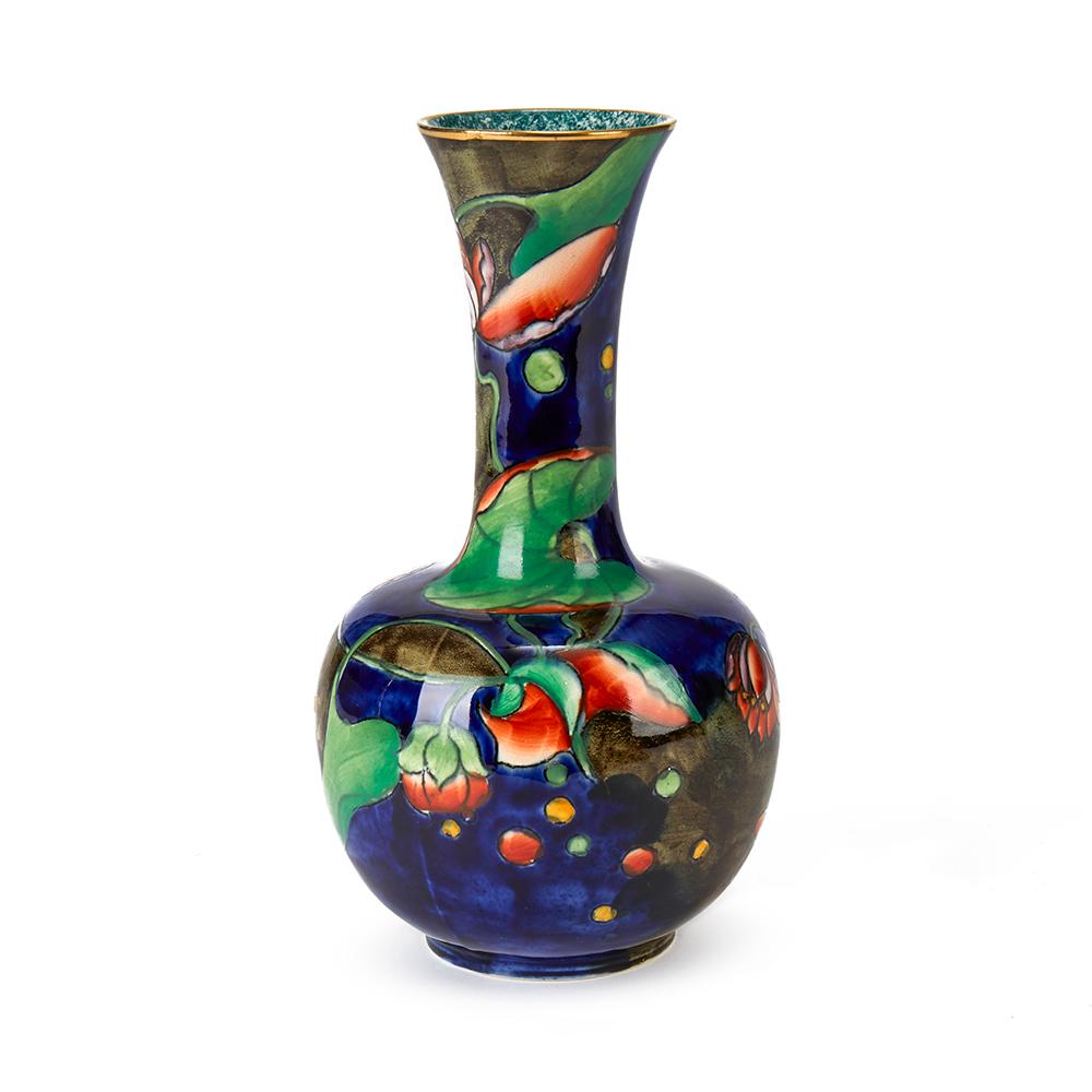 A very fine hand painted S Hancock & Sons Coronaware art pottery bottle shaped vase hand painted and signed by Molly Hancock in the Water Lily pattern in colored enamels on a blue ground. The vase has a gilded top rim with mottled finish to the