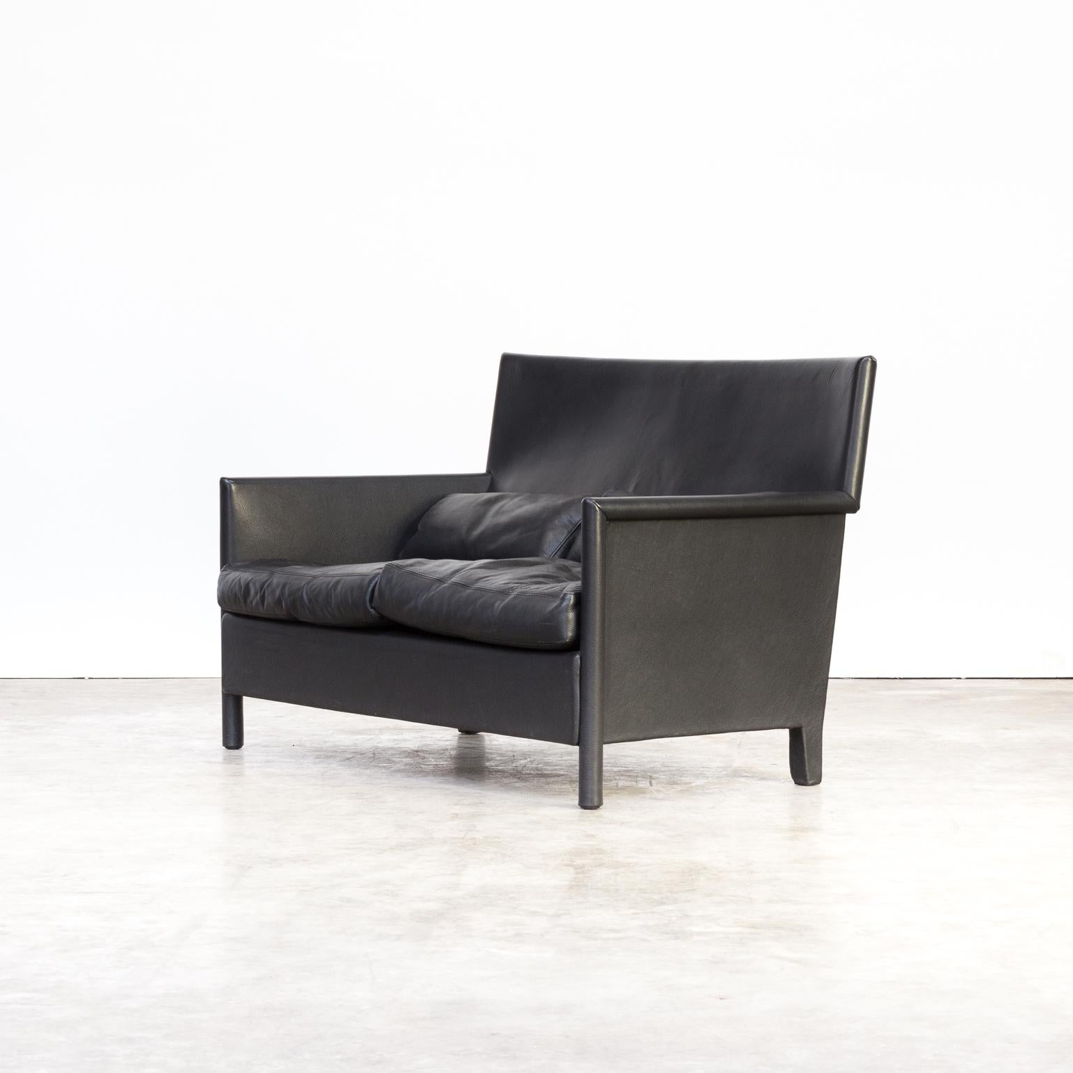 Highly comfortable double seat black leather sofa by the Italian workshop/studio Molteni & Co. The frame of the sofa has been wrapped in leather and the armleggers are in small though comfortable rounded leather. Beautiful detailed design. Good