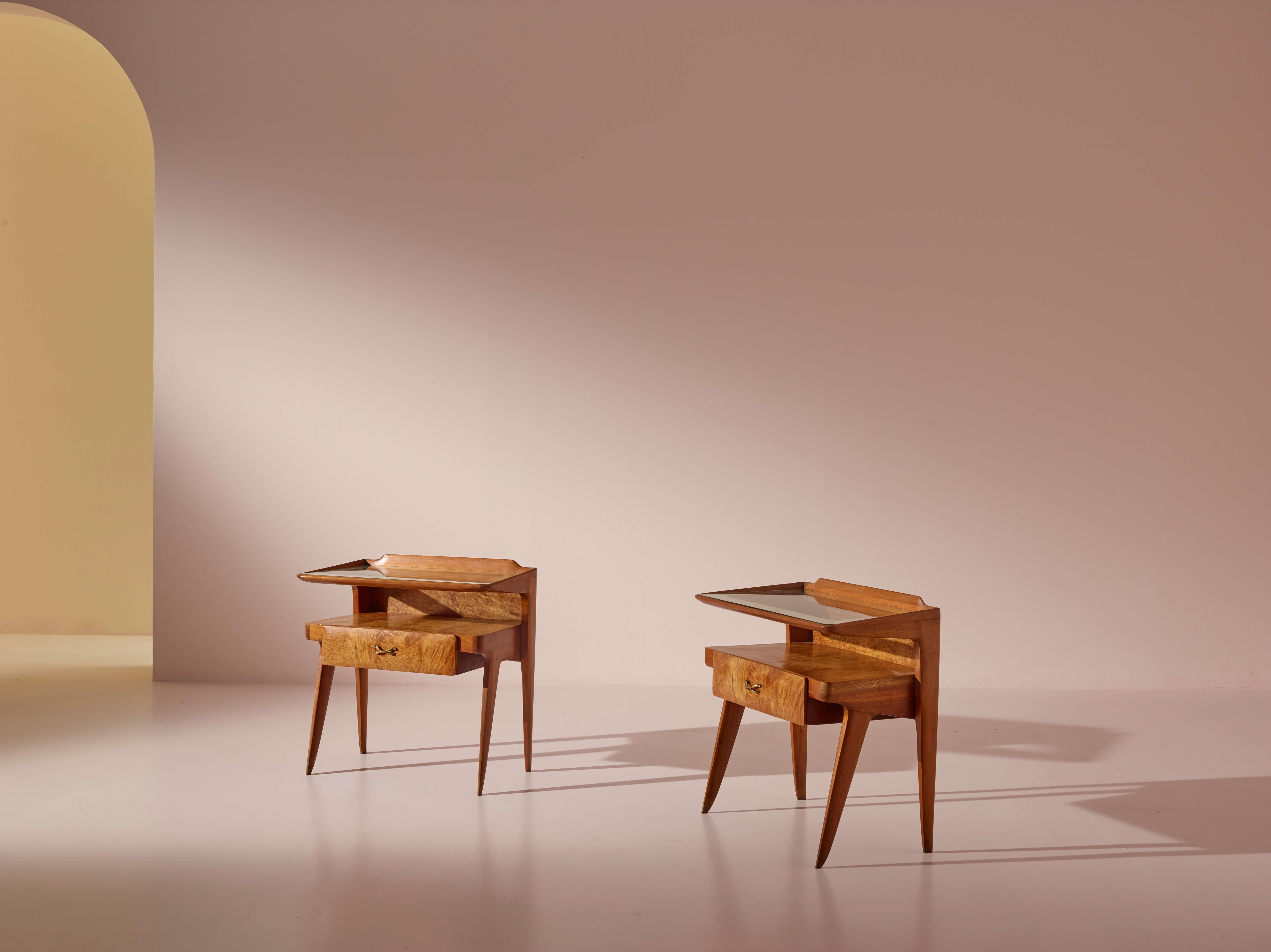 A beautiful and rare pair of nightstands in walnut, walnut burl, and glass, Molteni production, 1950s

These walnut nightstands feature an elegant and distinctive design with an unexpected visual impact. Their slender legs extend outward from the