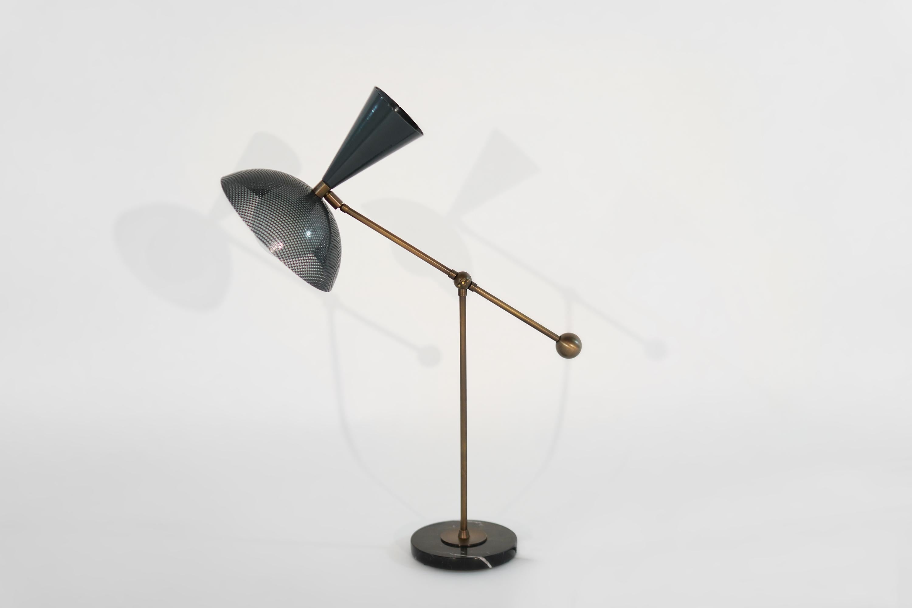 The Molto table lamp or desk lamp is a fresh, new take on Italian modernism, featuring a spun-metal mesh shade, brass counterweight, and a heavy black marble base. This lamp articulates in two places: the arm joint moves up and down and has a