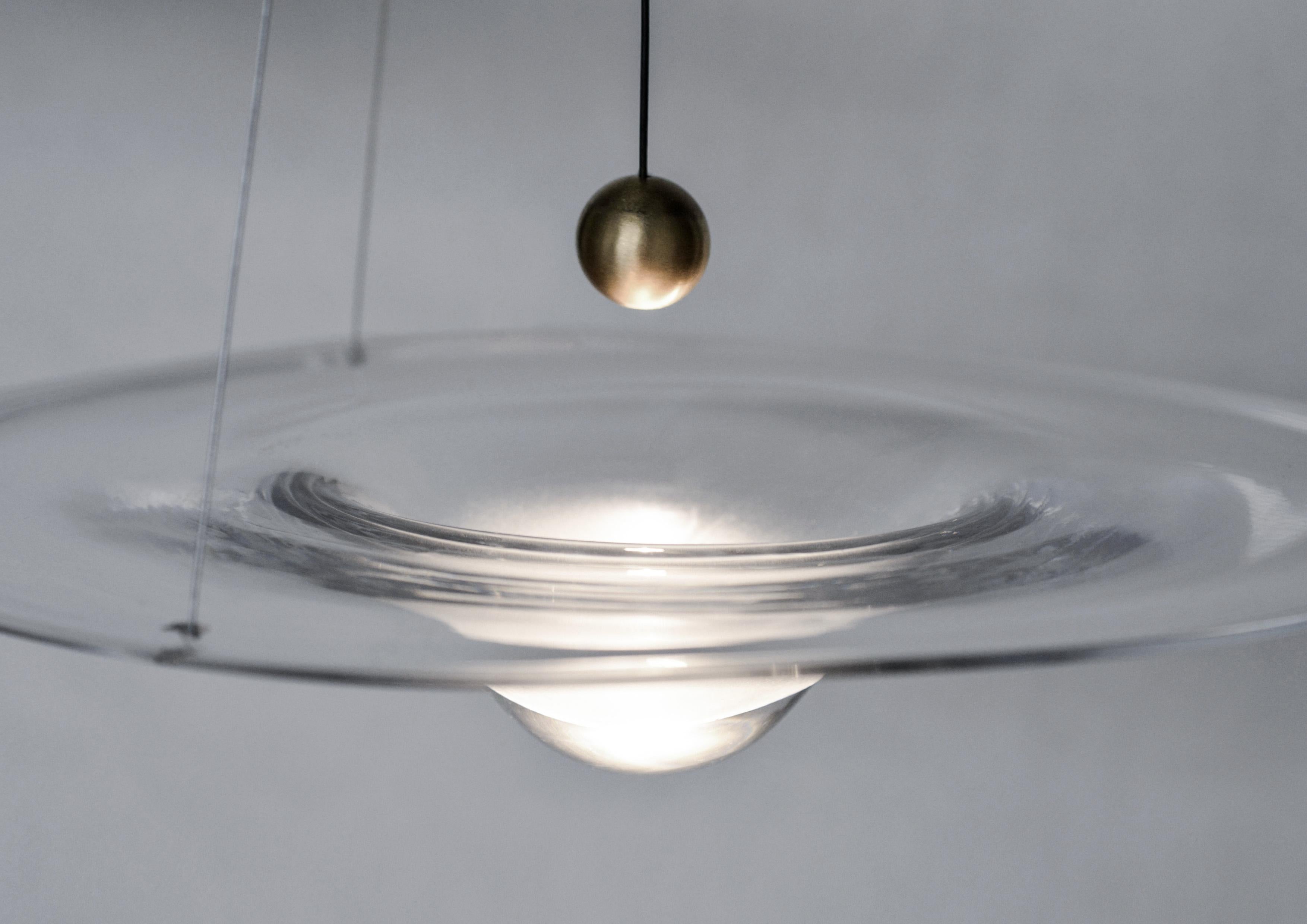 There is a moment when a clinging bead of water, in quiet orb-like suspension, becomes a droplet. The droplet reflects its surroundings while gathering light within.? There is a moment when molten glass transforms from liquid to solid.? This instant