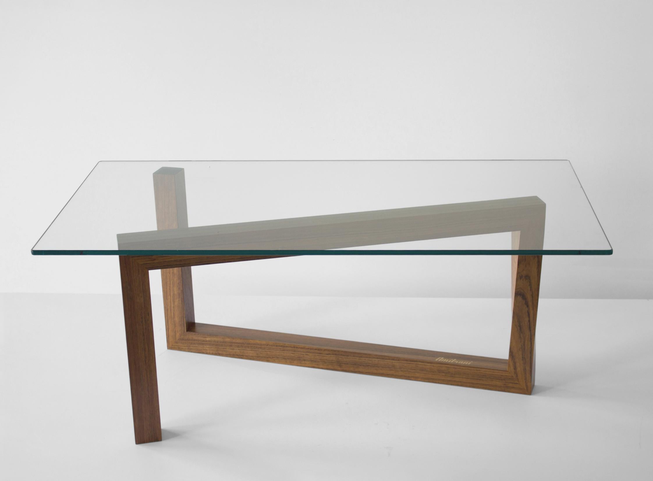 Momento coffee table puts together solid wood and glass. A minimal and synthetic shape that finds its key in torsion.
A twist that allows the square section of the piece to continue along all the path without interruption, and create a solid base