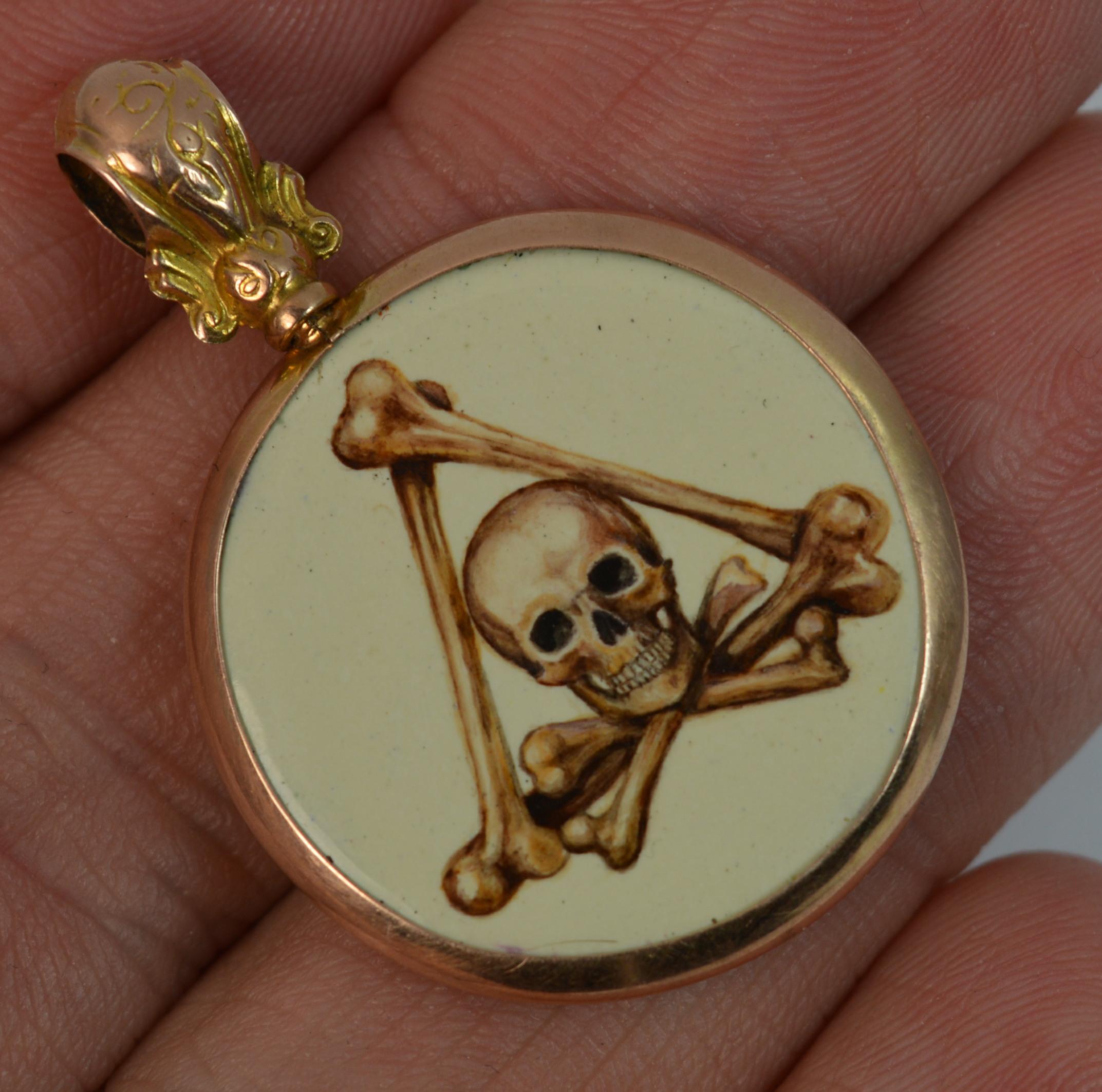 
A stunning 9 carat rose gold skull design pendant.

The circular disc is of a momento mori design with a skull to the centre of three larger bones.

The panel a hand painted and kiln fired piece of contemporary period.

Set into a simple hallmarked