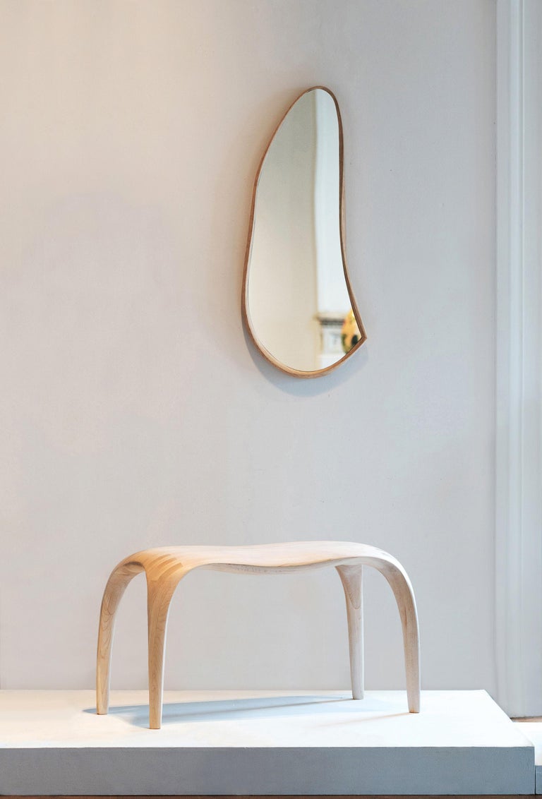 Momentum Mirror uses the technique of free-form bent-lamination to take the beauty of twisted bent wood-veneer forms, and preserve them into a solid object. Thirty or more layers of thin veneer are carefully laminated in place to create the form,