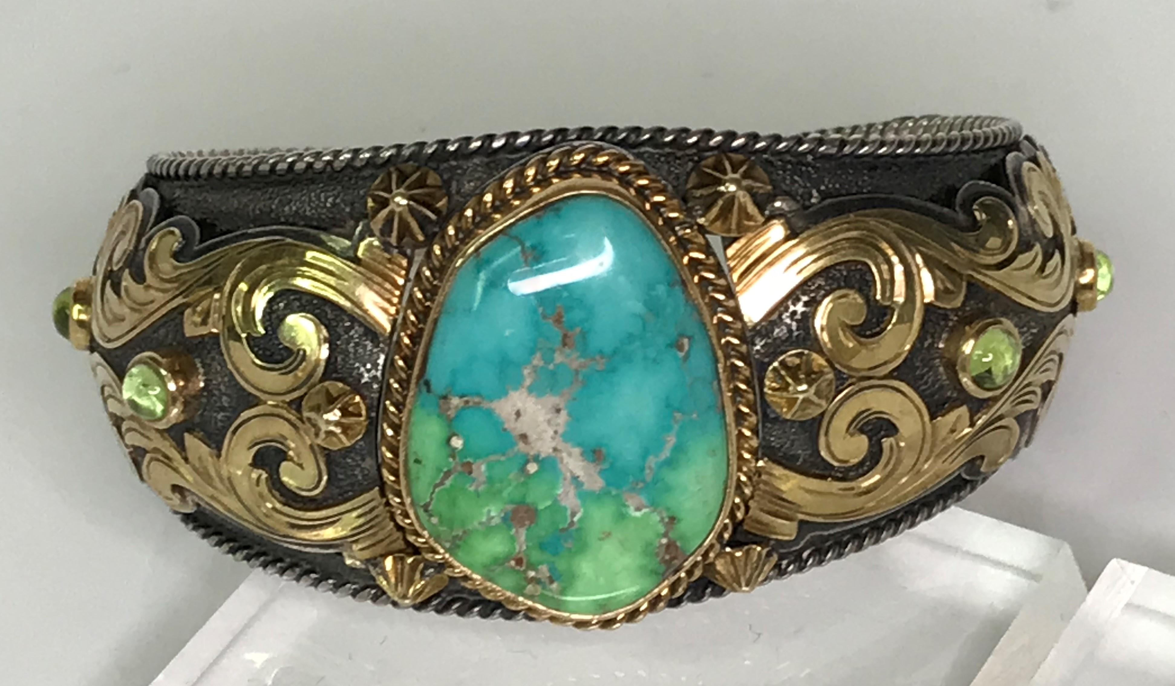 This one-of-a-kind bracelet will definitely get attention!
By designer Mona Van Riper, excellent craftsmanship and unique design.
18 karat yellow gold and sterling silver.
Center stone is a slightly oval, irregular shape turquoise with blue and