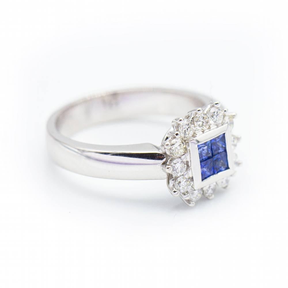 MONACO Women's Ring in White Gold  12 Brilliant Cut Diamonds weighing approx. 0.47 cts. in H/VS quality ! 4 Princess Cut Sapphires weighing 0.40ct. invisibly set  Size 12  18kt white gold  8.98 grams.  The central motif has a diameter of approx.