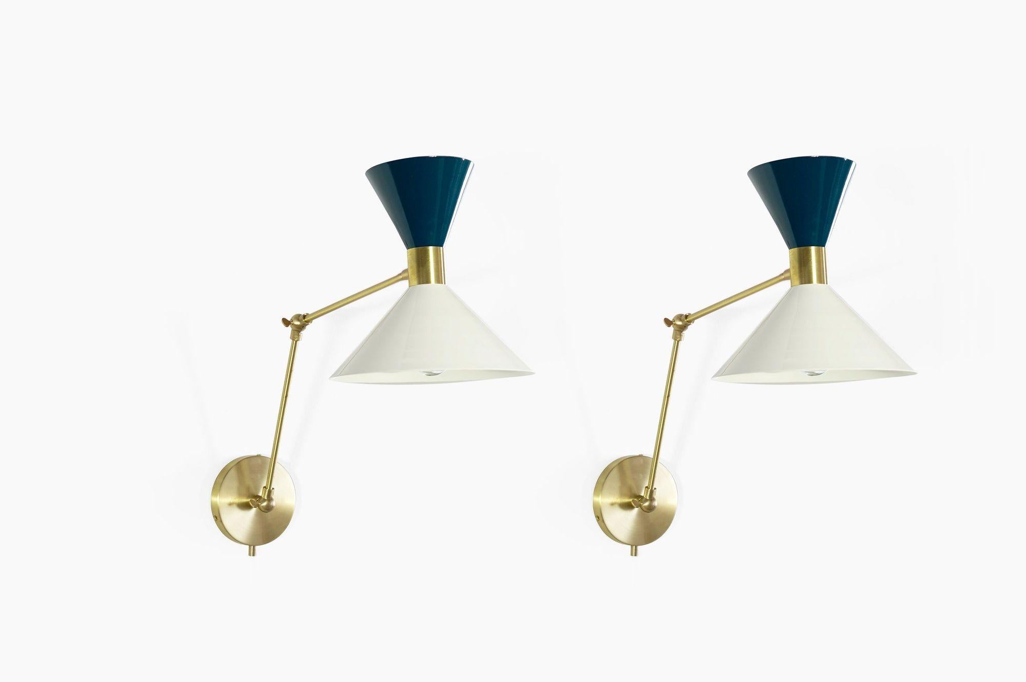 Monarch is a large scale wall-mount reading lamp or sconce with articulated arms. The wide brass band and dramatically scaled flared cone makes the Monarch a strong design statement. Swiveling head allows for cone adjustment. Arms articulate at both