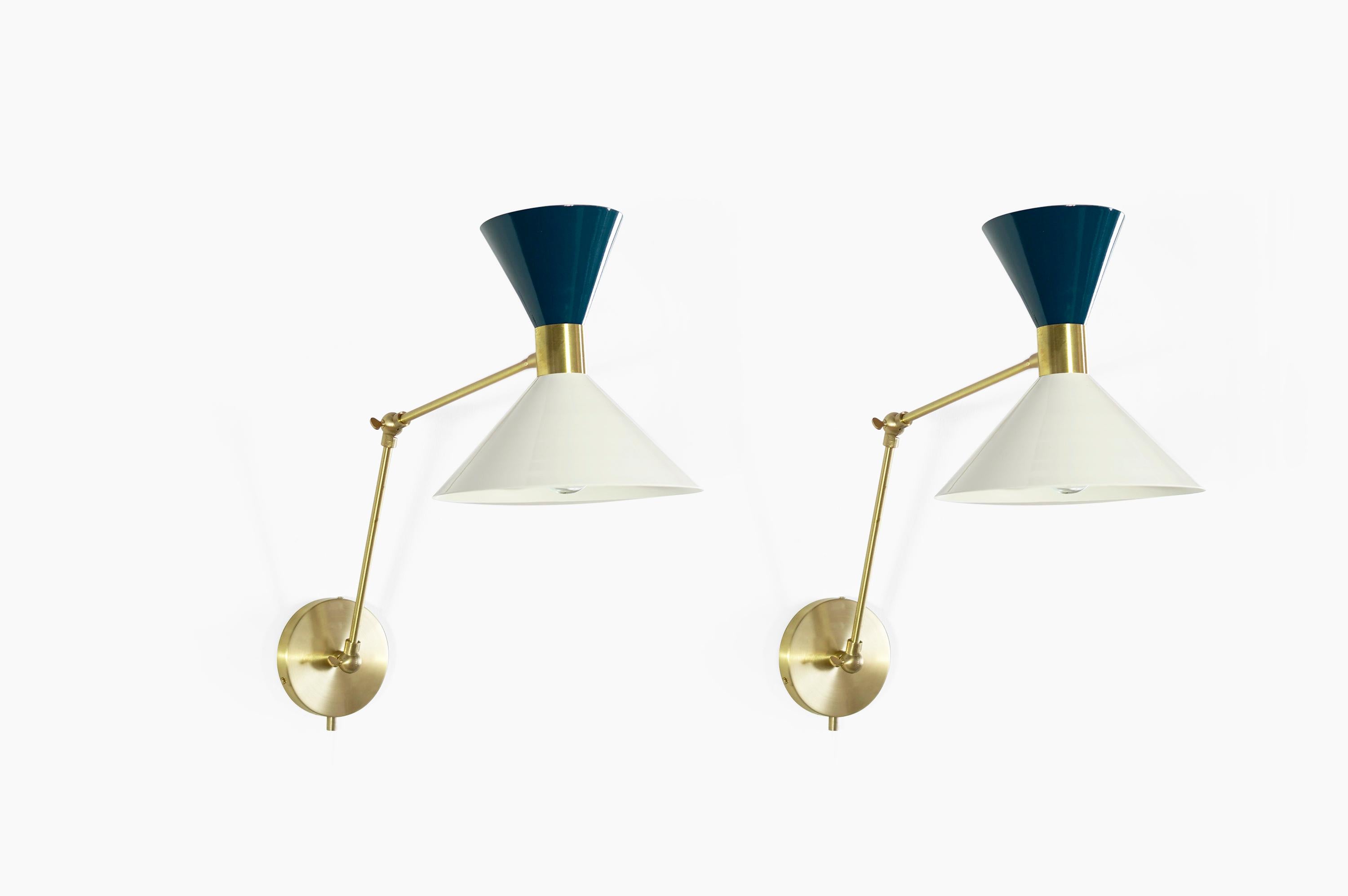 Monarch is a large scale wall-mount reading lamp or sconce with articulated arms. The wide brass band and dramatically scaled flared cone makes the Monarch a strong design statement. Swiveling head allows for cone adjustment. Arms articulate at both