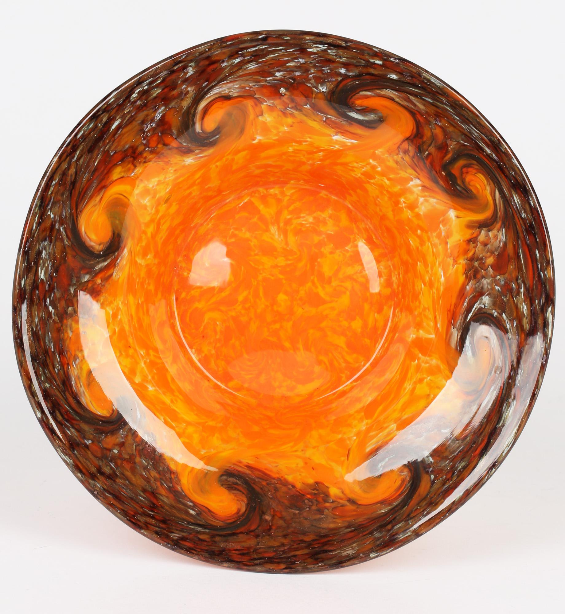 A good quality Scottish Art Deco glass bowl with bright orange and brown swirling patterning by Monart. The rounded art glass bowl has a recessed centre with a wide rim and has a bright mottled orange and yellow glass centre with a swirling pattern