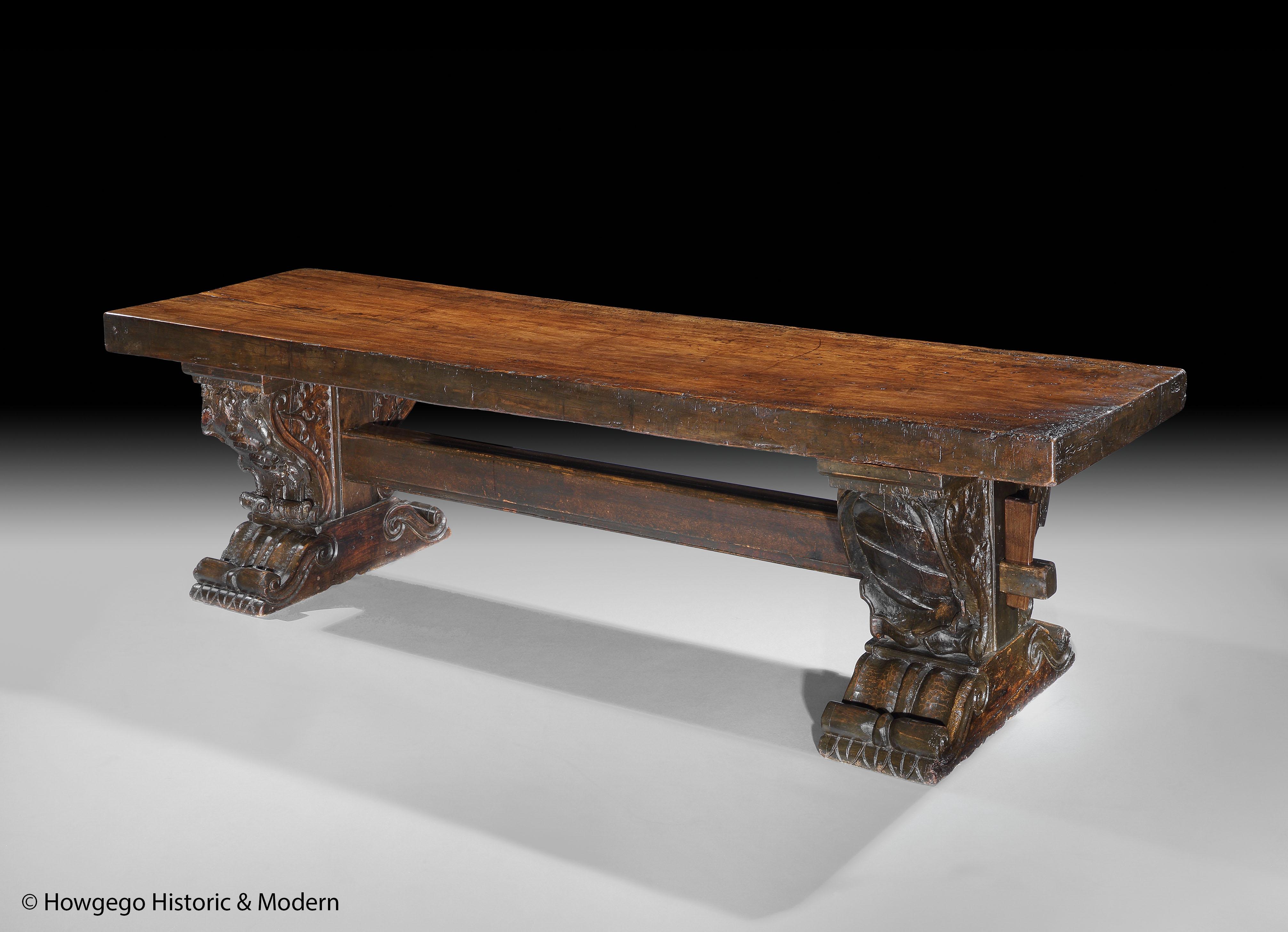 A massive, 14-16 seater, antiquarian, milanese, renaissance-revival, monastery, trestle table with 10ft long, 4 ¼” thick, single plank walnut top & oak trestles carved with an armorial, the heraldic charge of the dukes of milan & heraldic