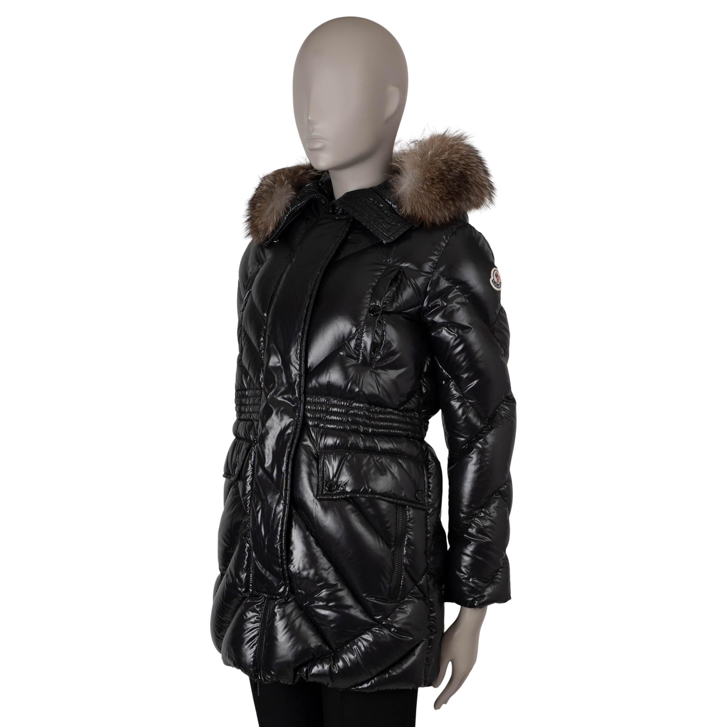 Questo parka a sbuffo Moncler Dinard, autentico al 100%, è realizzato in poliammide laqué di nylon nero lucido (100%) e presenta una silhouette sartoriale che si allarga sul fondo. L'elastico in vita migliora la vestibilità, mentre la pelliccia di
