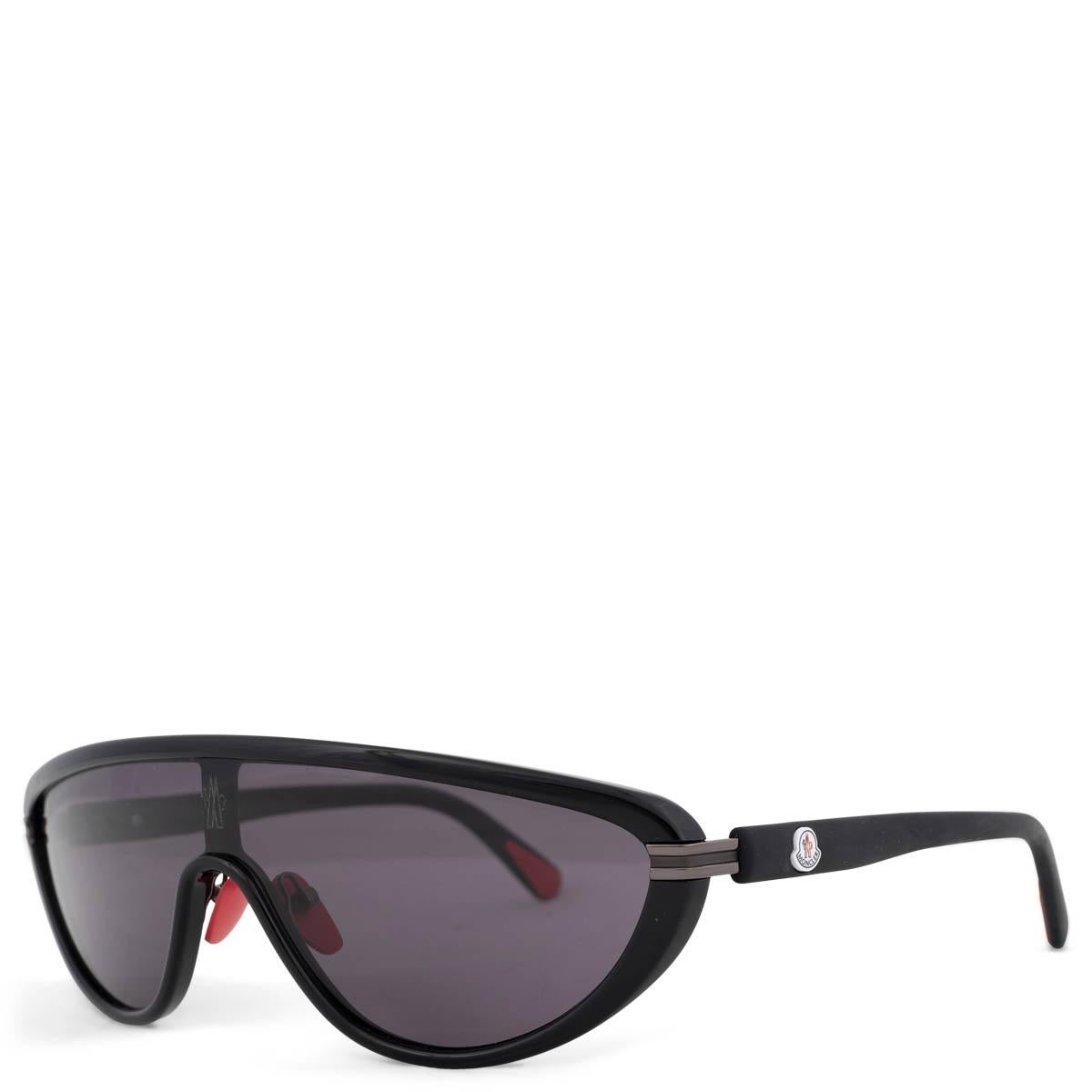 Les lunettes de soleil Moncler Vitesse shield, 100% authentiques, présentent une monture en acétate noir et des verres teintés ton sur ton avec des détails rouges. Les lentilles sont des filtres de catégorie 3. Ils ont été portés et sont en
