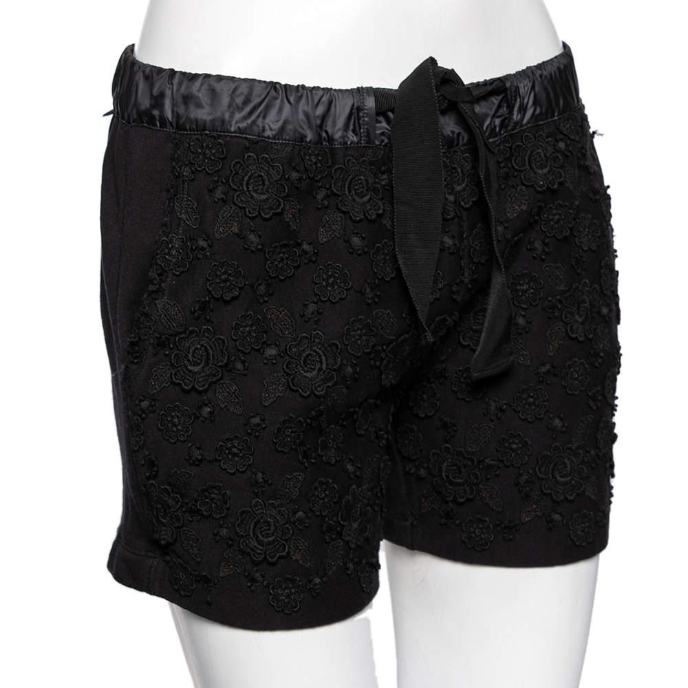 Update your collection with these stunning shorts from the House of Moncler. Tailored using black printed cotton fabric these shorts feature floral appliques. Look chic as you wear them.