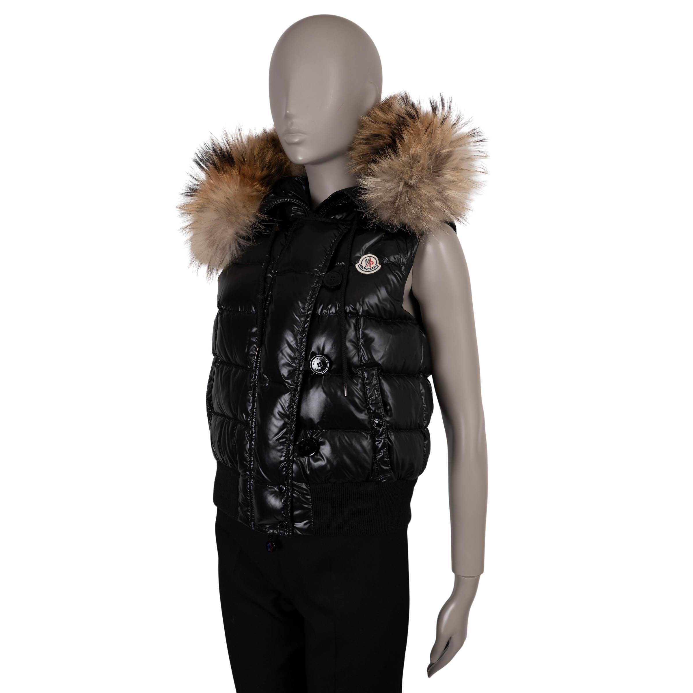 Questo giubbotto di Moncler Tarn, autentico al 100%, è realizzato in poliammide nera lucida (100%). Con una silhouette ispirata ai bomber, presenta un cappuccio con pelliccia di procione staccabile, due tasche con bottoni e una toppa con logo sul
