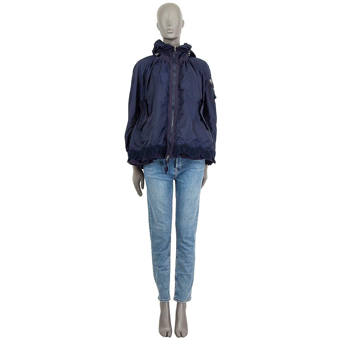 100% authentic Moncler flared hooded jacket in navy blue polyamide (100%). Embellished with a broderie anglaise hemline. Features two buttoned flap pockets on the front, one buttoned pocket and a zip pocket at the sleeve. Opens with two zippers on