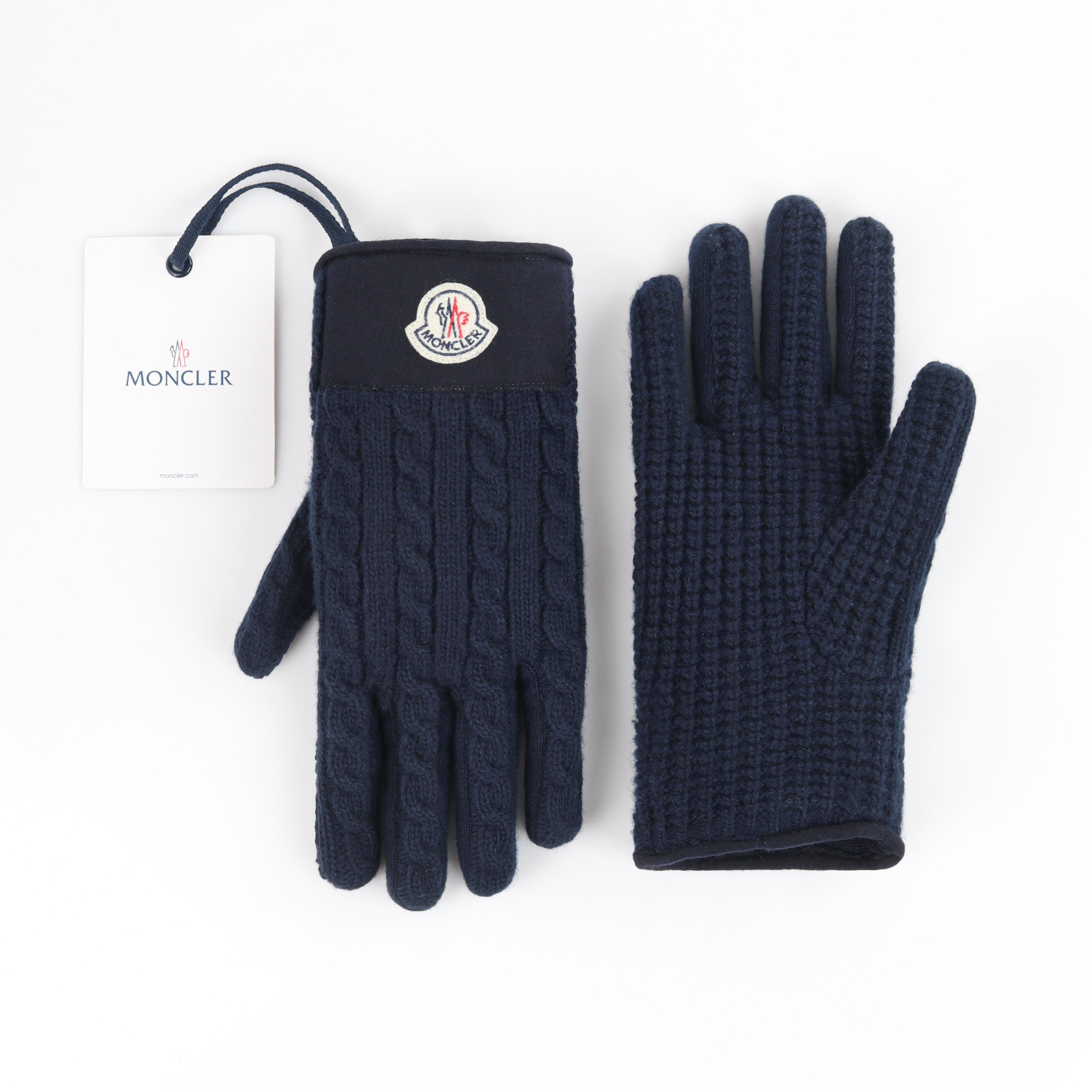 MONCLER c.2017 Navy Blue Chunky Cable Knit Logo Patch Winter Gloves w/ Tags
 
Brand/Manufacturer: Moncler 
Circa: 2017
Style: Knit gloves
Color(s): Shades of blue, off white, red
Lined: Yes 
Unmarked Fabric Content (feel of): Wool
Additional Details