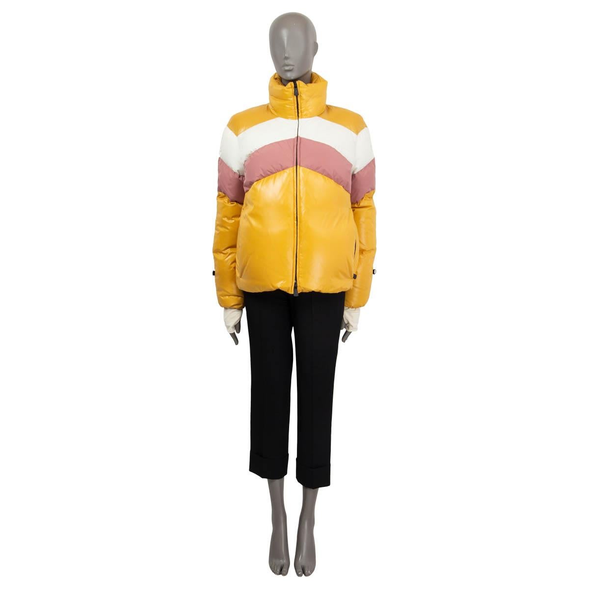 100% authentic Moncler Grenoble Lamar puffer down jacket in mustard ,white and pink nylon (100%). Features a stand collar with stowaway hood, zipper pockets and a ski pass pocket. Closes with a concealed water resistant two-way zipper. Lined