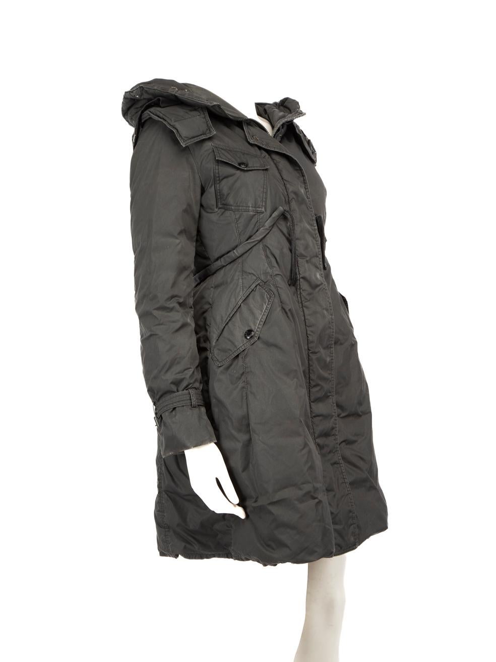 CONDIT ist gut. Der Mantel weist leichte Gebrauchsspuren auf. Verfärbungen in allen Bereichen der Jacke. Kleine Löcher an beiden Ärmelbündchen und am Saum. Anlaufen der Beschläge. Fehlende Verarbeitung auf der rechten Seite des Taillenbandes Zugband