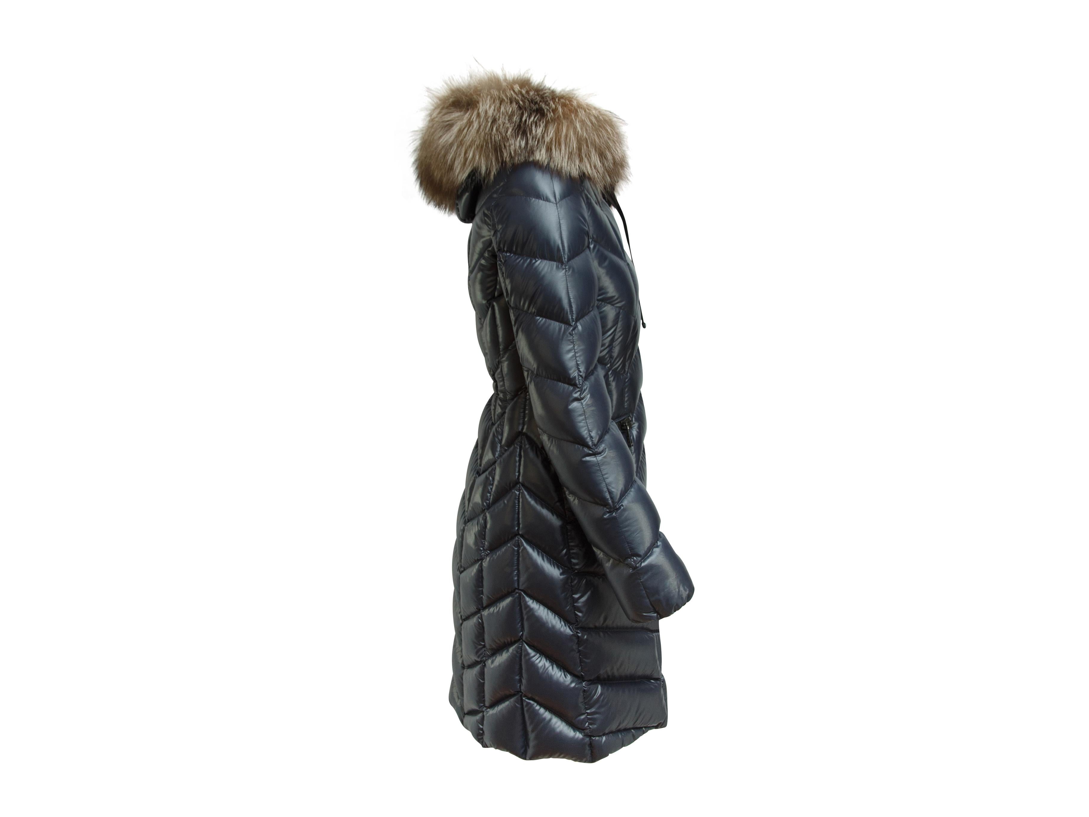 Product details:  Navy blue puffer coat by Moncler.  Fox fur-trimmed hood with drawstring.  Long sleeves.  Zip-front closure.  Waist zip pockets.  32