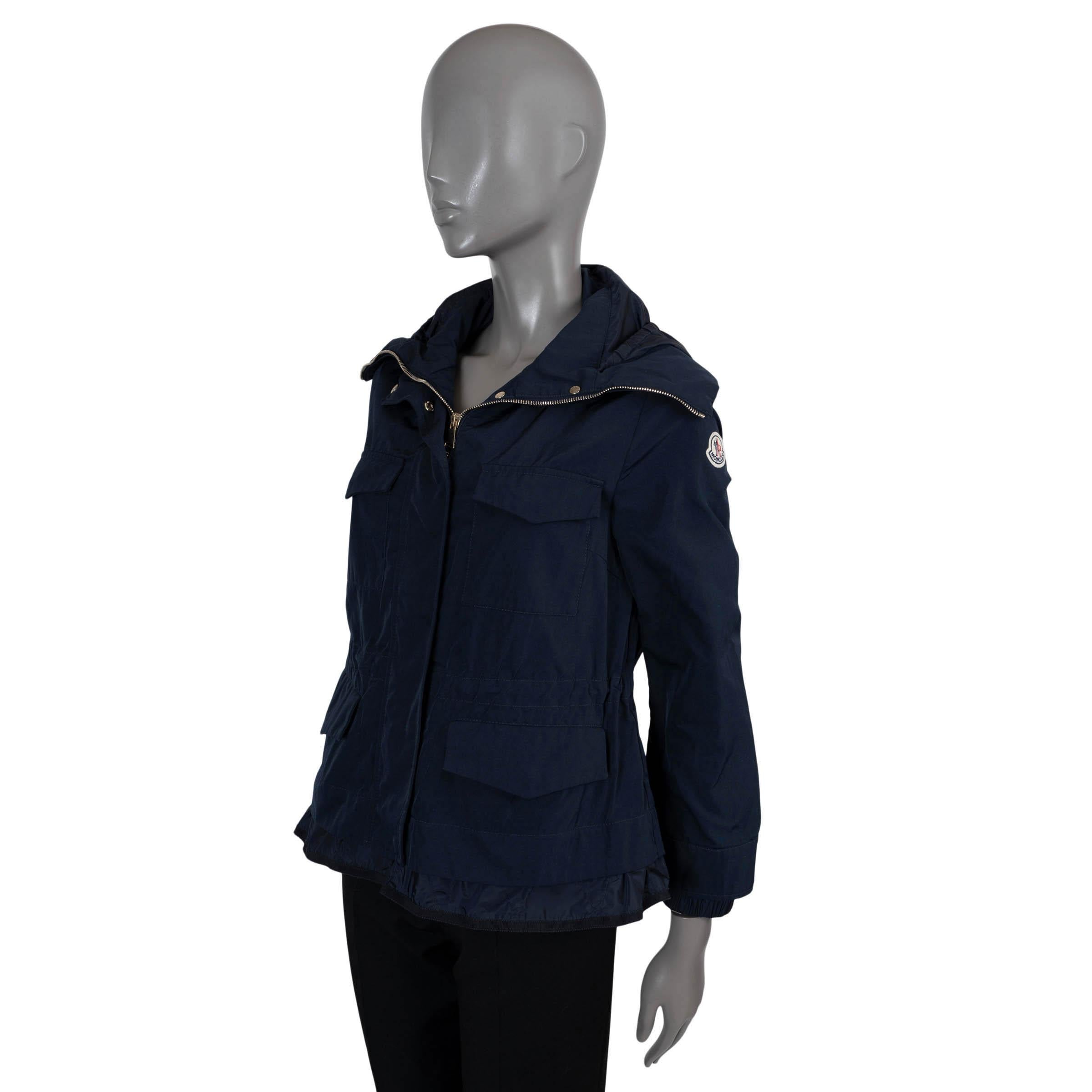 Cortavientos Moncler Eclaire 100% auténtico de poliamida (70%) y algodón (30%) de color azul marino. Tiene capucha, cuatro bolsillos con solapa y botón a presión en la parte delantera, puños y dobladillo internos elásticos y cintura con cordón