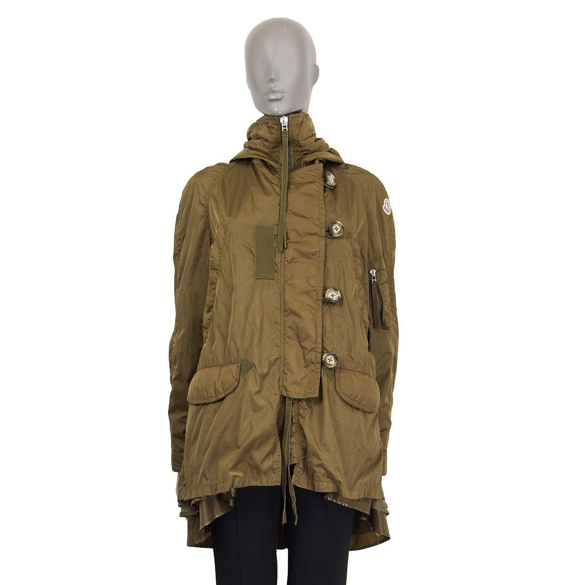 100% authentic Moncler hooded high-collar windbreaker jacket in olive-green polyamide (99%) and polyurethane (1%) with two slit pockets on the chest and two flap pockets on the front. Closes with a concealed zipper and four buttons on the front. Has