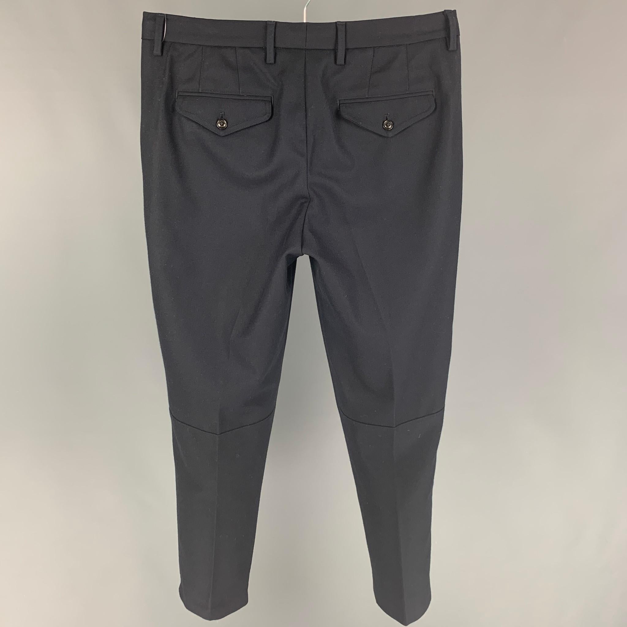 MONCLER dress pants comes in a navy blue virgin wool featuring a pleated front, front tab, and a zip fly closure. 

Very Good Pre-Owned Condition.
Marked: 48

Measurements:

Waist: 34 in.
Rise: 10 in.
Inseam: 28 in. 