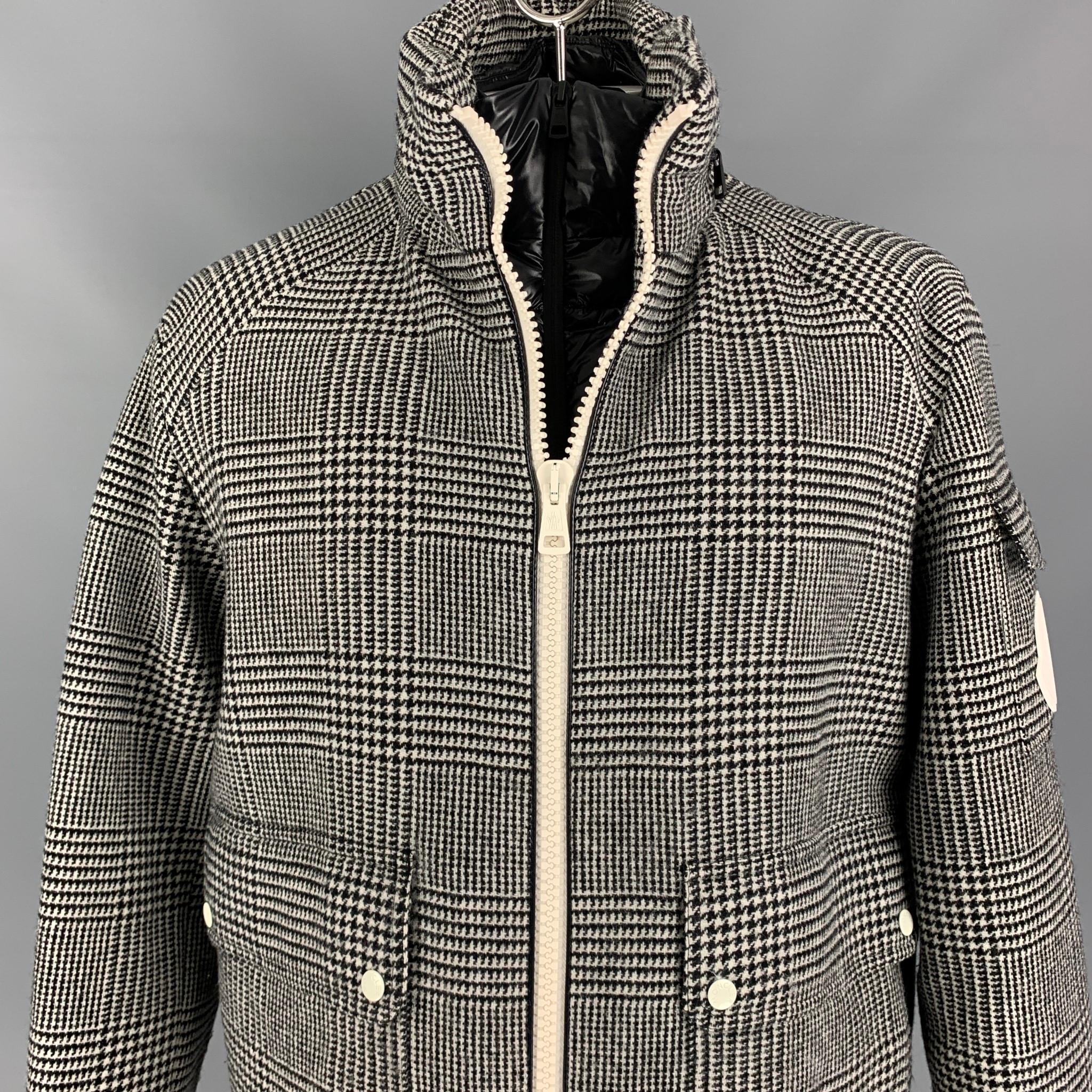MONCLER jacket comes in a black & white plaid wool with a down fill quilted liner featuring a hidden hood design, high collar, flap pockets, ribbed hem, inner layer, and a full zip up closure. Made in Romania. 

Excellent Pre-Owned