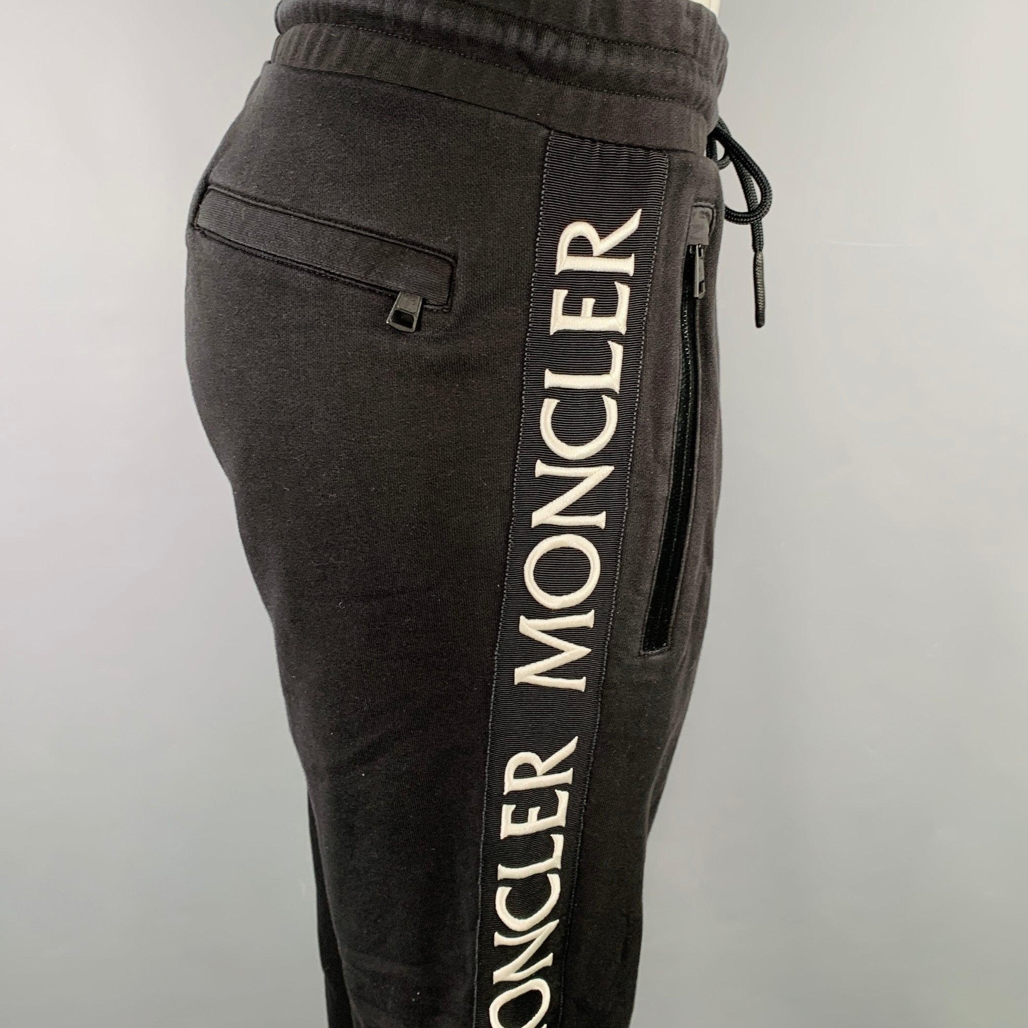 Pantaloni casual Moncler
in cotone nero con strisce laterali bianche con logo e chiusura con coulisse. 
Eccellente condizione di usato. 

Contrassegnato:   L 

Misure: 
  Vita: 33 - 37 pollici  Cavallo: 9 pollici  Cavallo: 30 pollici  
  
  
