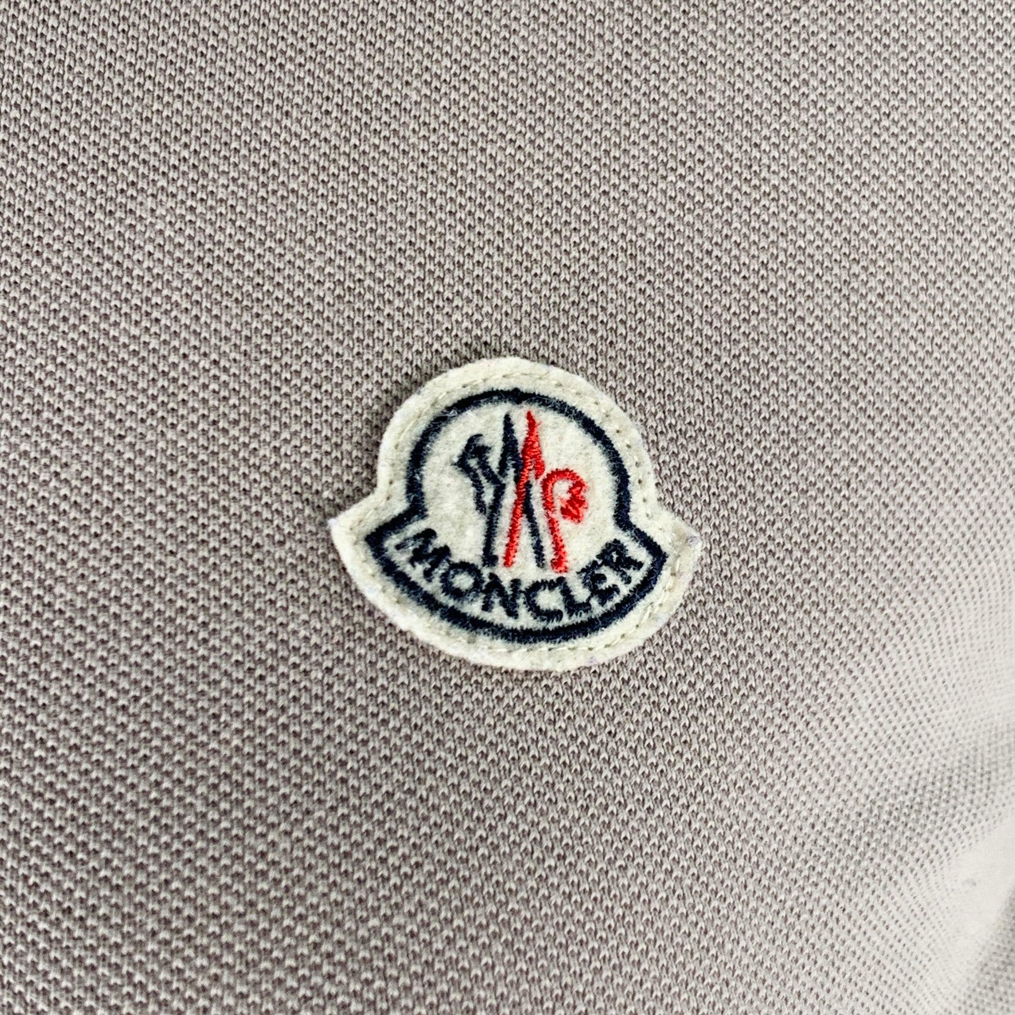 MONCLER casual top
in a grey cotton pique featuring a white stripe trim, slim fit, and half placket button closure. Very Good Pre-Owned Condition. Moderate marks underarms, which are hard to see unless looking closely. 

Marked:   L 

Measurements: