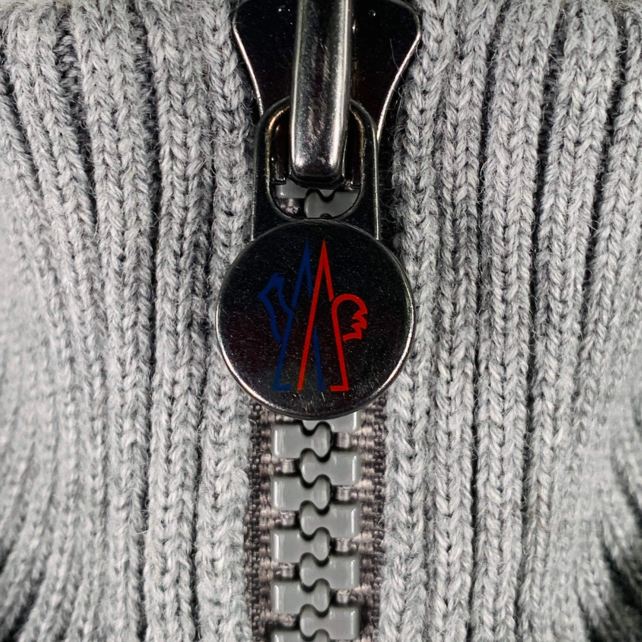 MONCLER jacket
in a
grey wool acrylic knit featuring a hooded style, quilted back and hood, and zip up closure. Made in Moldavia.Excellent Pre-Owned Condition. 

Marked:   XL 

Measurements: 
 
Shoulder: 19 inches Chest: 46 inches Sleeve: 27.5