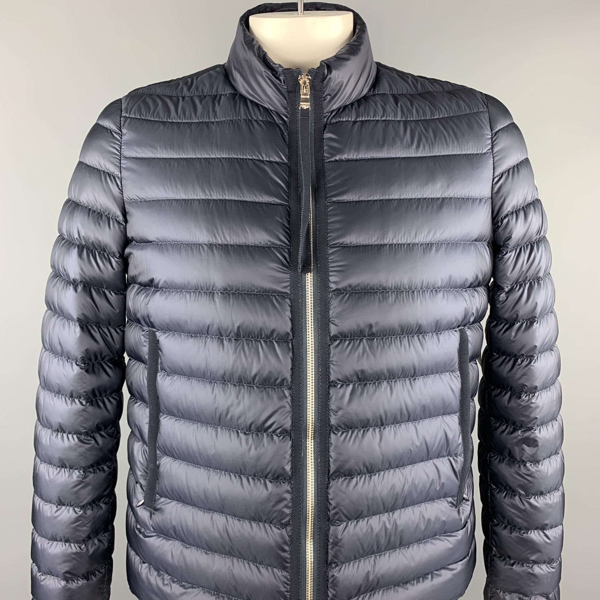 MONCLER LONGUE SAISON puffer jacket coms in light weight quilted goose filled down windbreaker fabric with a high neck, zip front, and drawstring elastic liner waistband. With pouch. 

Excellent Pre-Owned Condition.
Marked: JP