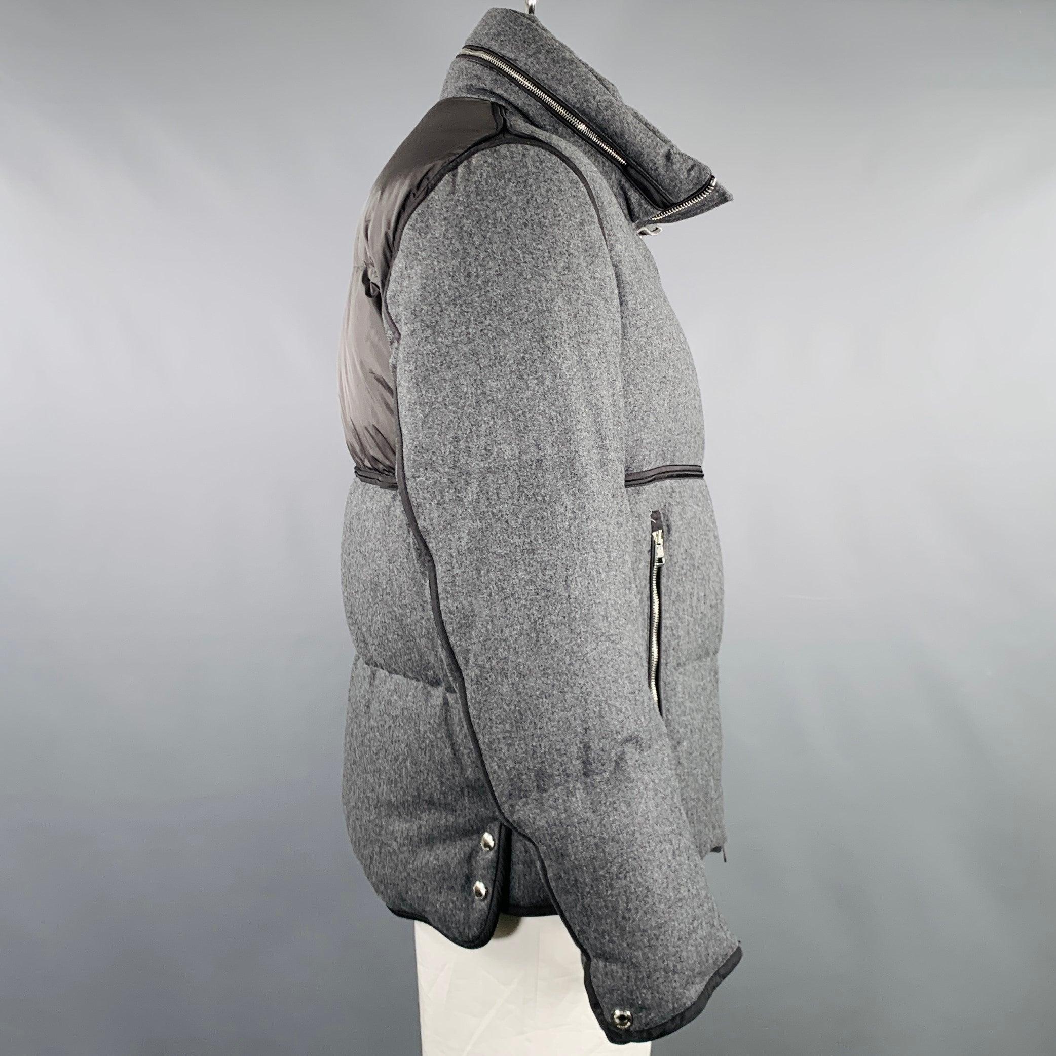 Chaqueta MONCLER
de lana gris con un estilo acolchado, detalles en negro, bolsillos con cremallera, capucha con cremallera y cierre con cremallera. Excelente estado de conservación. 

Marcado:   6 

Medidas: 
 
Hombro 18 pulgadas Pecho: 48 pulgadas