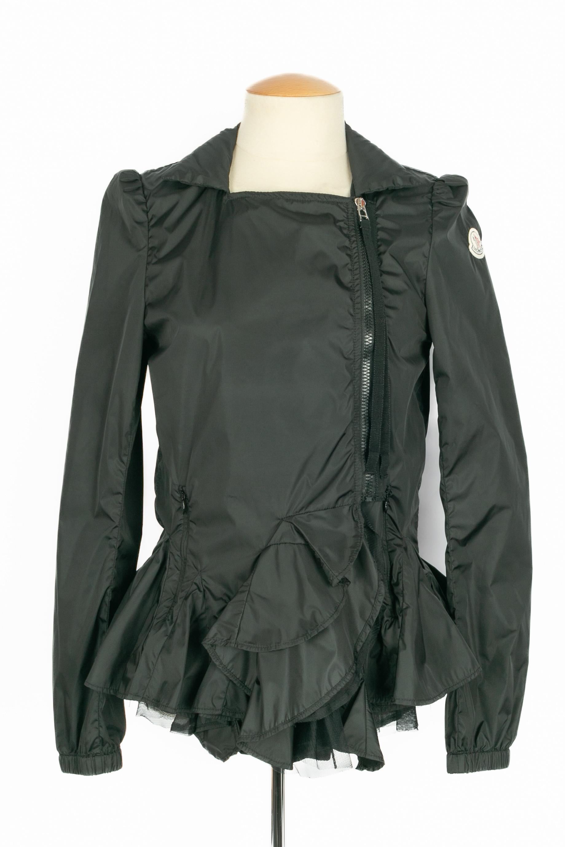 MONCLER - Schwarze wasserdichte Jacke mit Volants am unteren Rand. Keine Größenangabe, es passt eine 36FR.

Bedingung:
Sehr guter Zustand

Abmessungen:
Schulterbreite: 40 cm - Brustumfang: 43 cm - Taillenumfang: 40 cm - Ärmellänge: 68 cm - Länge: 58