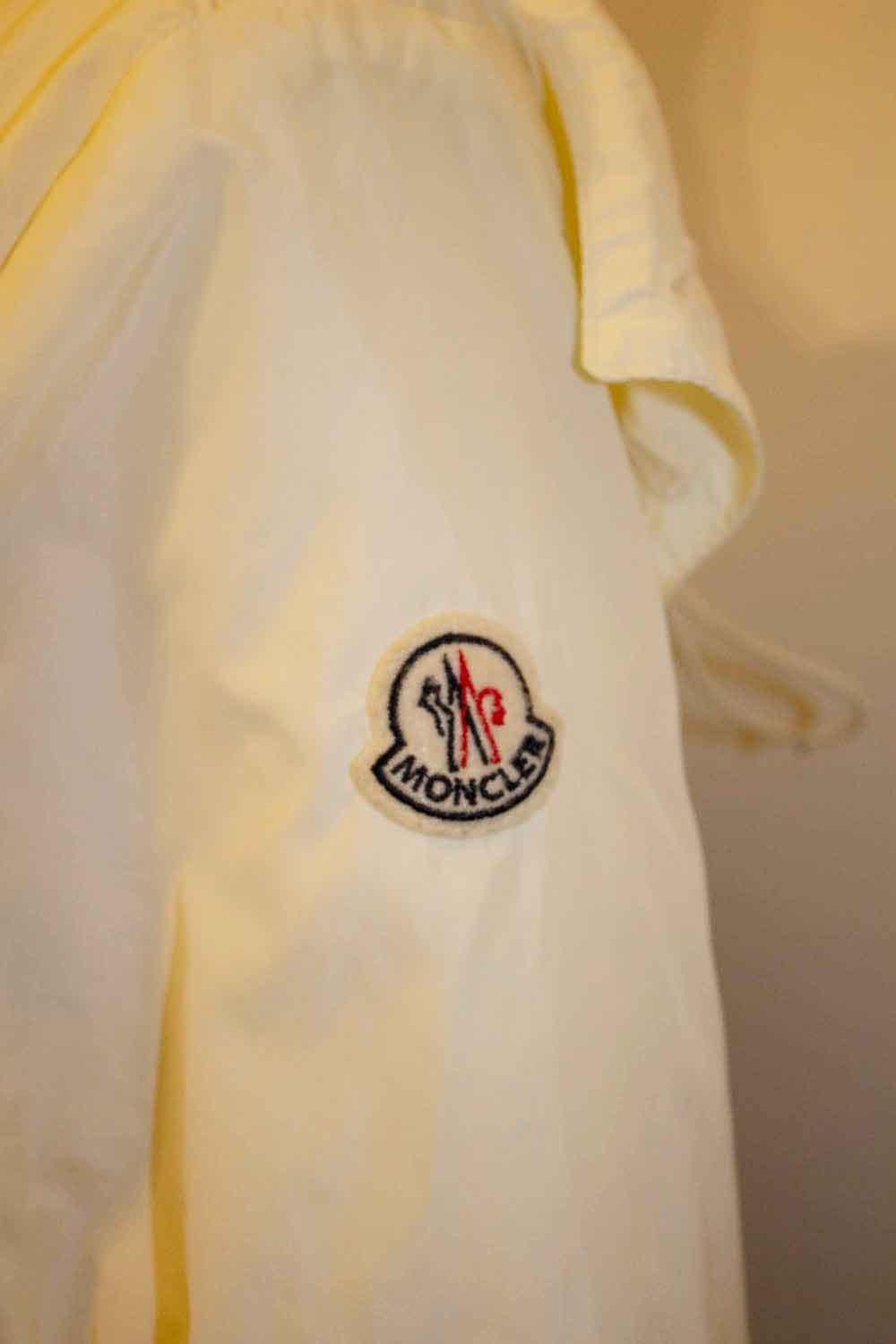Une veste légère et amusante signée Moncler. La veste, portant le numéro de série Z8E1000, comporte quatre poches sur le devant, des boutons aux poignets et un logo sur le bras gauche. Il est doté d'une ceinture interne réglable. La capuche est