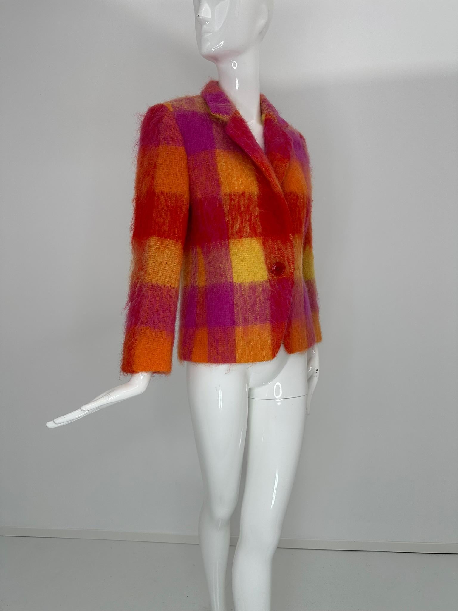 Mondi, mohair, angora, cashmere blend jacket marked size 34. Large scale fuzzy, plaid in hot pink, yellow & orange. Notched lapel collar and single button front closure. Cut away hem front & long sleeves. Lined in red rayon. 
Bright casual jacket