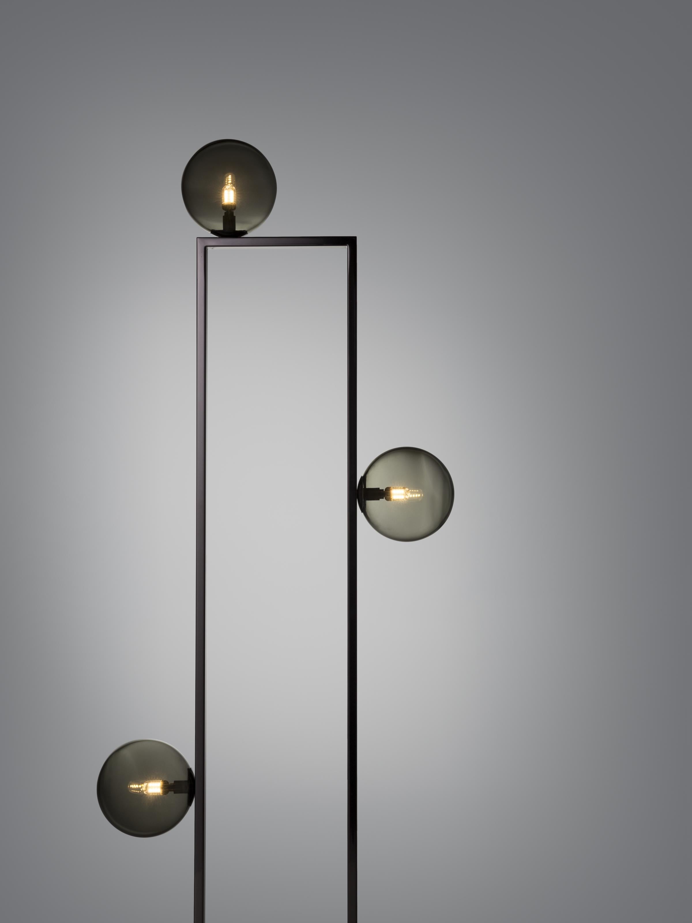 The Mondrian Floor Lamp is inspired by the painter Piet Mondrian and his harmonious use of vertical and horizontal lines. This timeless light combines the rhythm of a geometric glass structure, with handmade Murano glass spheres.