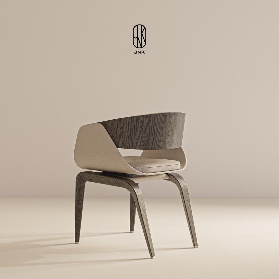 La chaise MONE CHAIR présente un design simple et élégant. 

Le dossier incurvé se distingue par sa texture en bois foncé, tandis que l'assise est revêtue d'un tissu doux et que les panneaux latéraux sont recouverts de cuir crème clair. Les pieds de