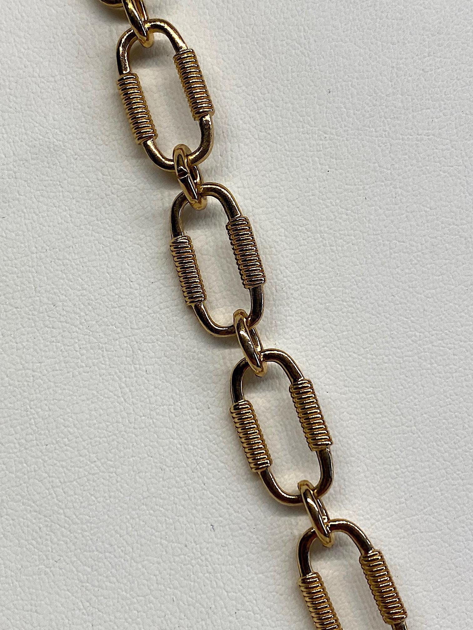 An elegant medallion cross style pendant necklace from the 1960s by famous American fashion jewelry company Monet. The cross is an interpretation of the Maltese cross in satin and shiny gold plate. It is suspended from a chain of small round and .75