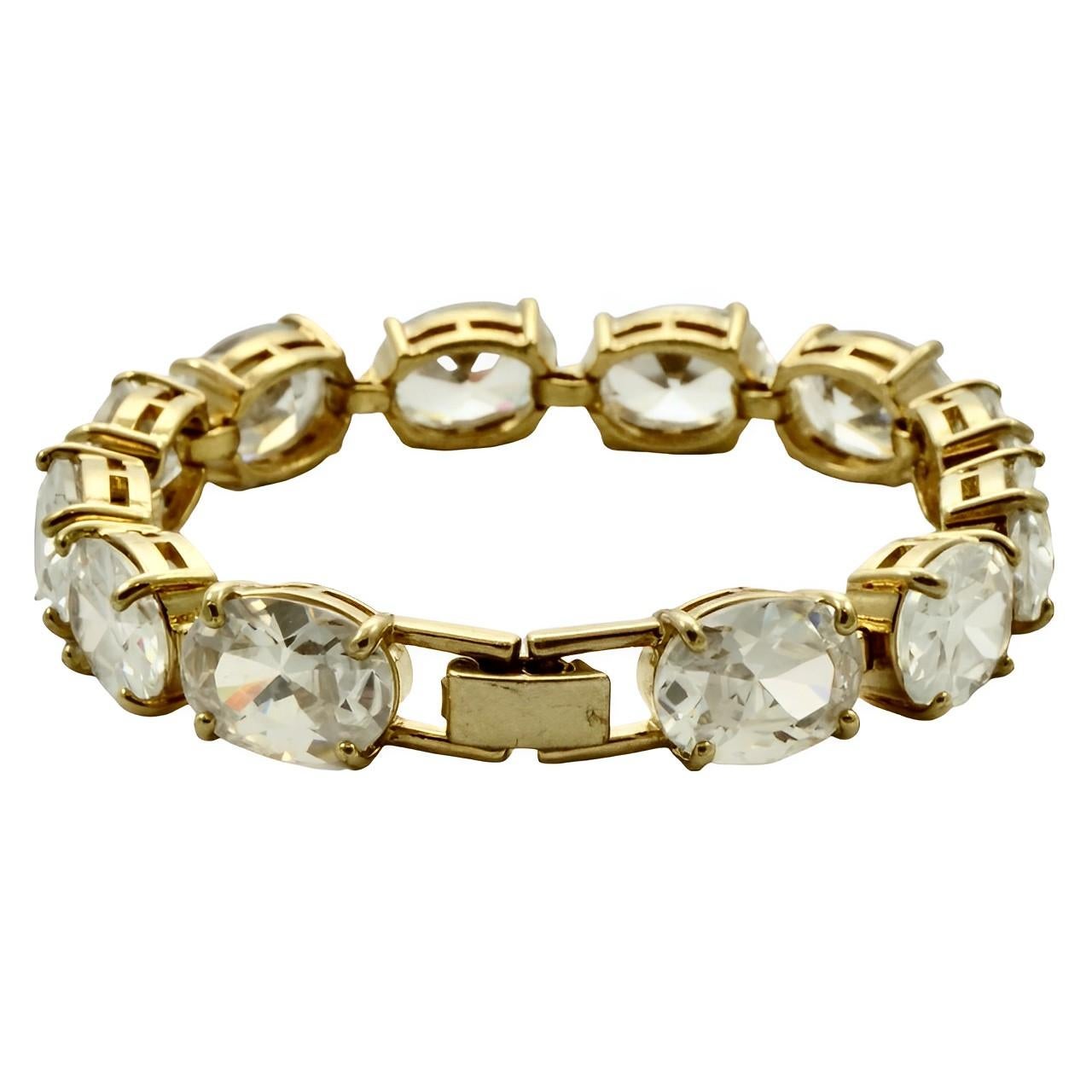 Beautiful Monet gold plated bracelet with large clear oval rhinestones in open back settings. Measuring length 19.2 cm / 7.5 inches by width 1 cm / .39 inch. There is scratching to the gold plating. The bracelet will arrive in its original