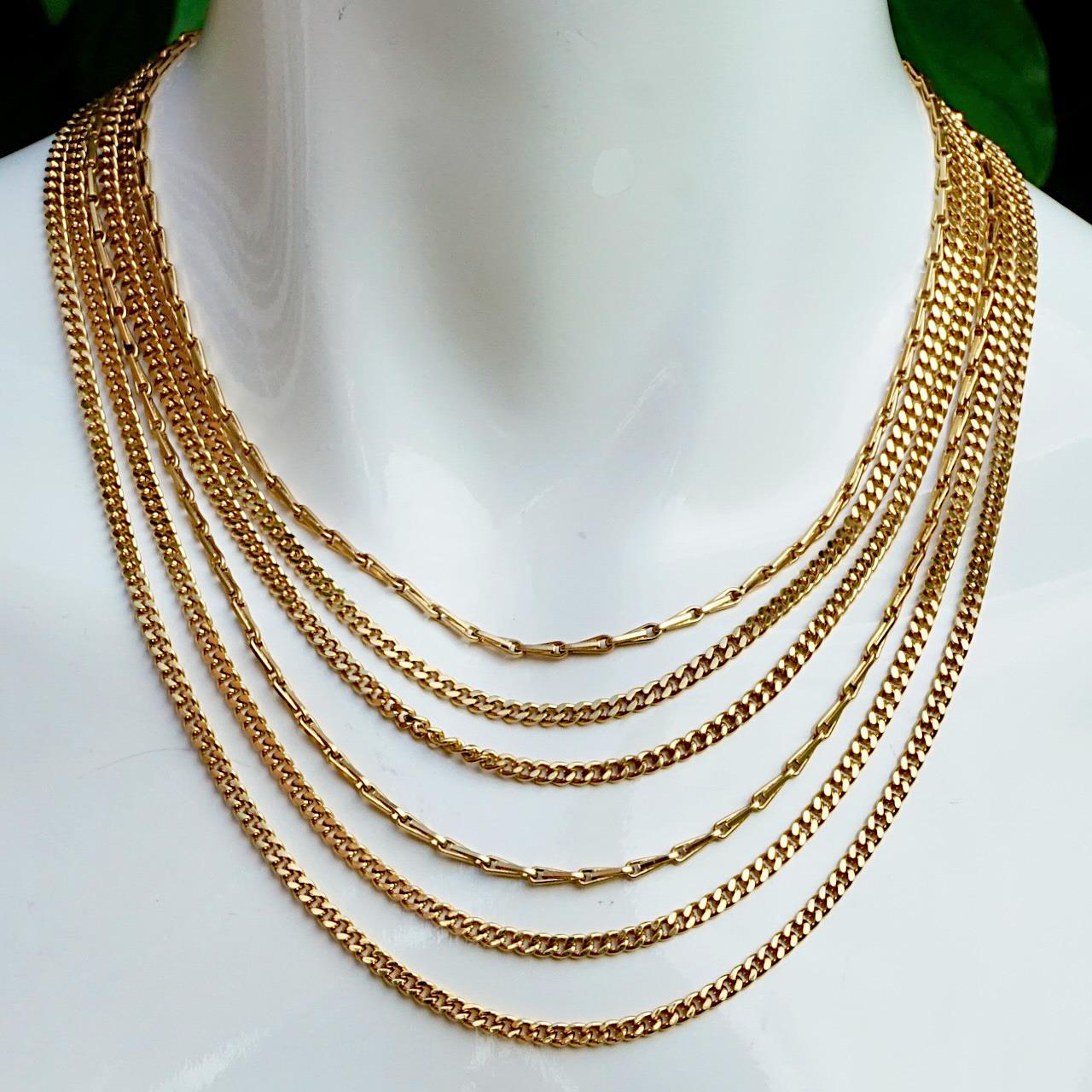 Monet gold plated necklace with six strands of curb and double link chains. The necklace has a fancy clasp and an extension chain. The shortest length is 38.8 cm / 15.27 inches not including the extension, the extension chain is 4.8 cm / 1.9 inches.