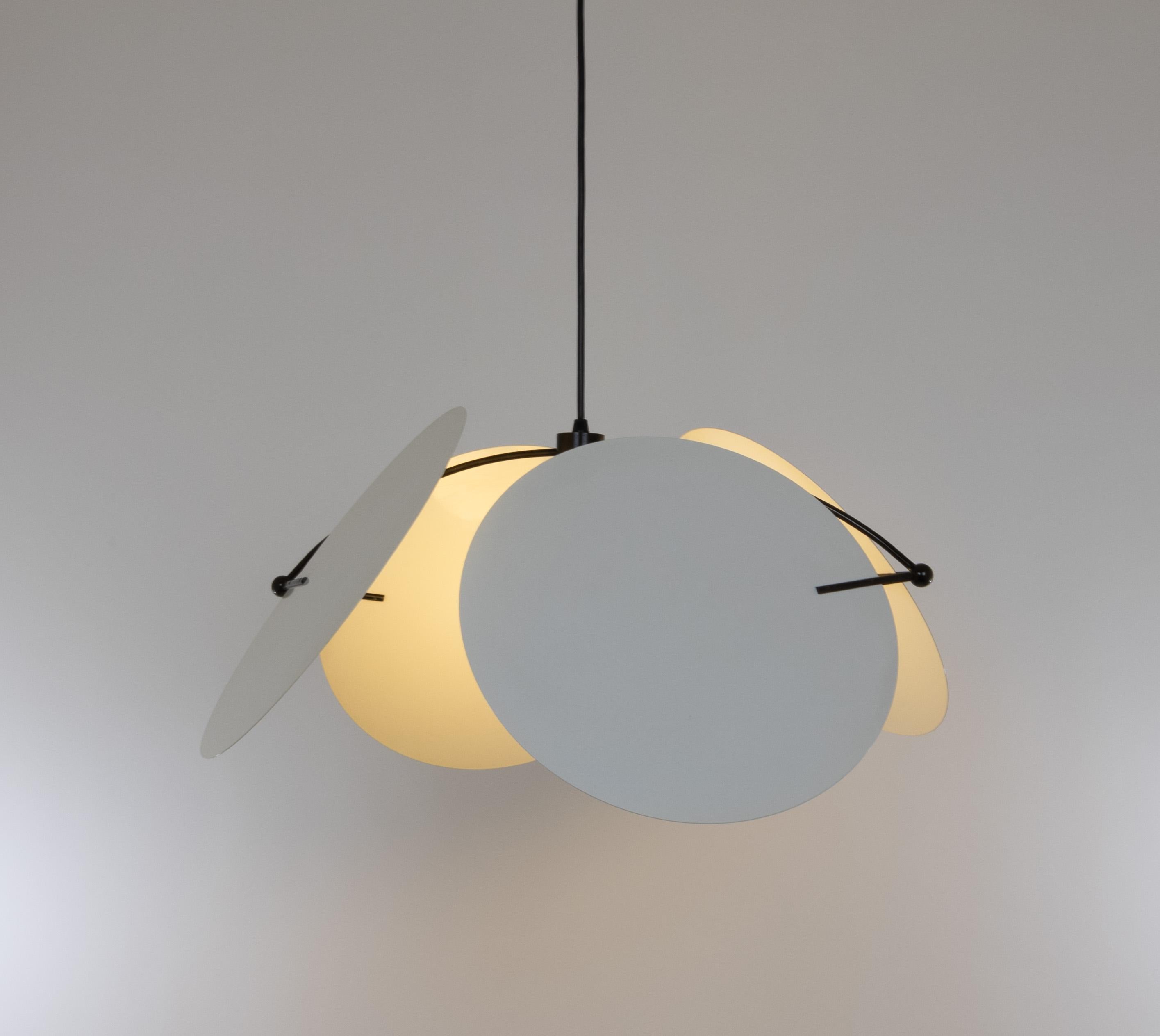 Pendente Monet, disegnato da Vico Magistretti nel 1980 e prodotto da O-Luce.

Il modello è composto da quattro dischi di alluminio verniciato collegati da un'asta metallica curva larga 62 cm (24 pollici) con piccoli giunti sferici.

I dischi