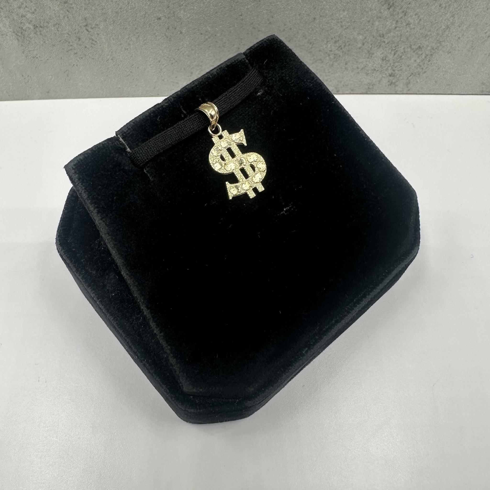 Ce pendentif ludique Money Sign en or jaune 14kt est parfait pour ajouter une touche élégante et symbolique à n'importe quel collier. Pesant 1 gramme, il est léger et confortable pour un usage quotidien. L'anse intérieure mesure environ 3,5 x 3,7