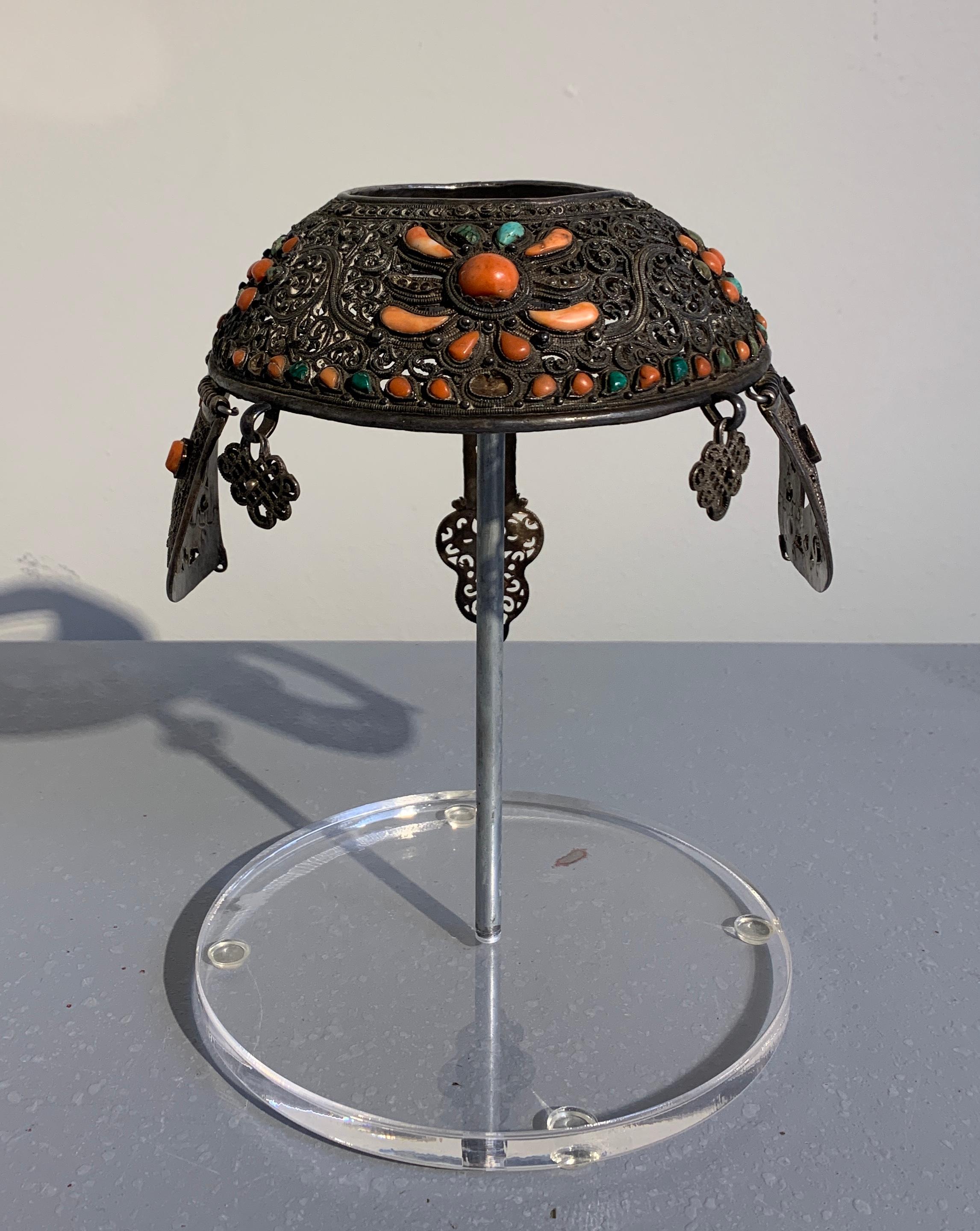 A fabulous Mongolian Khalkha silver crown headdress inset with coral, turquoise and malachite. 
The cast silver crown, of circlet form, features intricate scrolling designs set with coral, turquoise and malachite. Two small hanging pendants to the