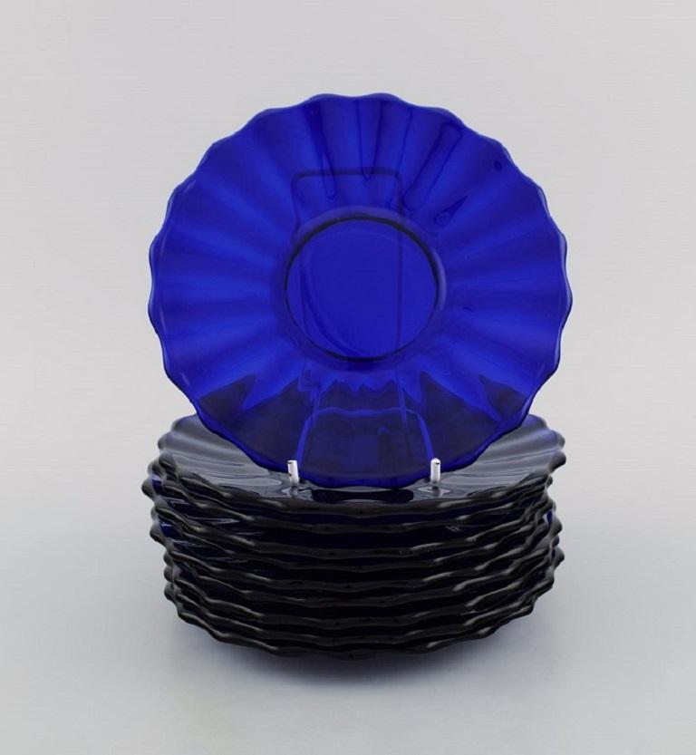 Monica Bratt for Reijmyre. 10 plates in blue mouth-blown art glass. Wavy design. 
Mid-20th century.
Measure: diameter: 18 cm.
In excellent condition with minor wear.